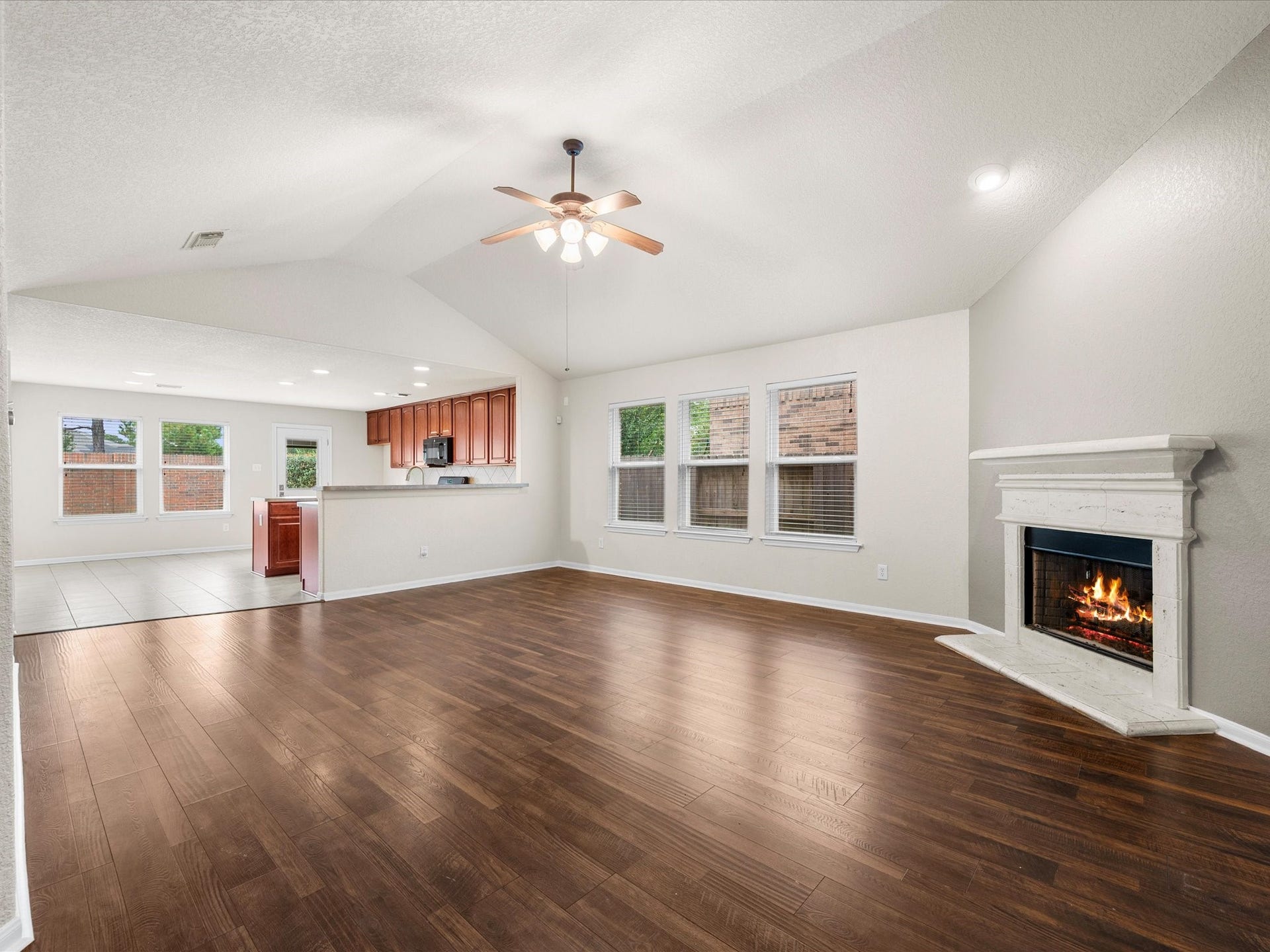 20118 Monarda Manor Court, Spring, TX 77379 The open-concept living area provides the perfect gathering space with soaring ceilings, abundant natural light, and a cozy fireplace serving as the rooms focal point.