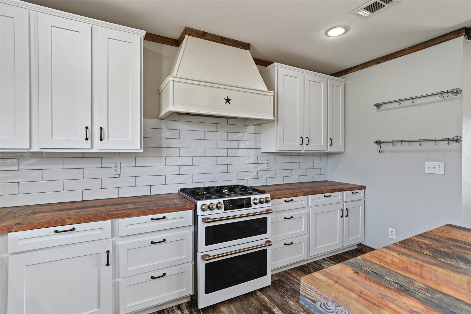 546 5th Street, Dickinson, TX 77539 This white kitchen is stunning with its double oven, tile backsplash, and accent range hood. Notice the pots and pan drawers
