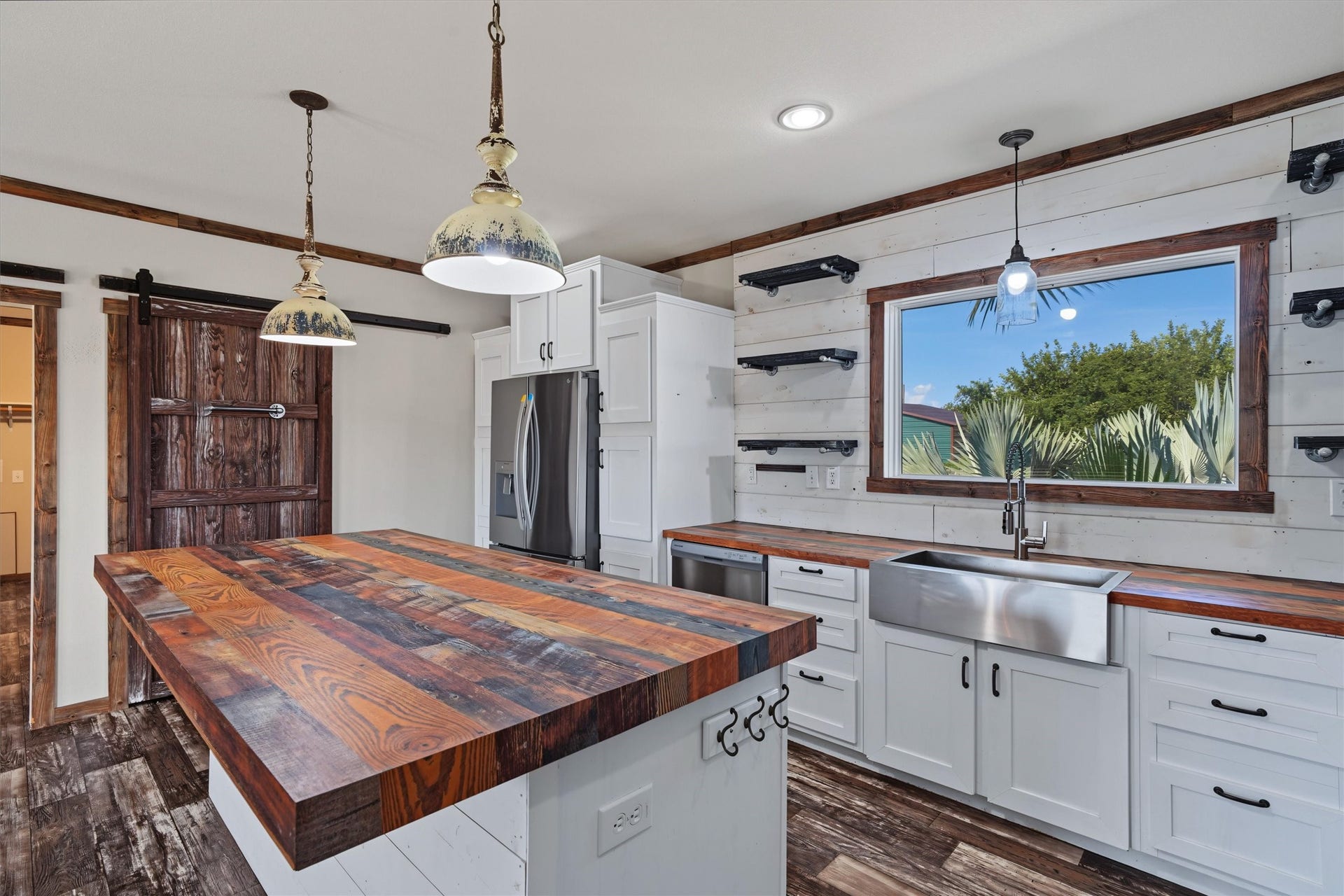 546 5th Street, Dickinson, TX 77539 View of those magnificent countertops. The barn door leads into the pantry. The large window over the apron sink maximizes natural lighting in the kitchen. Plenty of storage in these cabinets