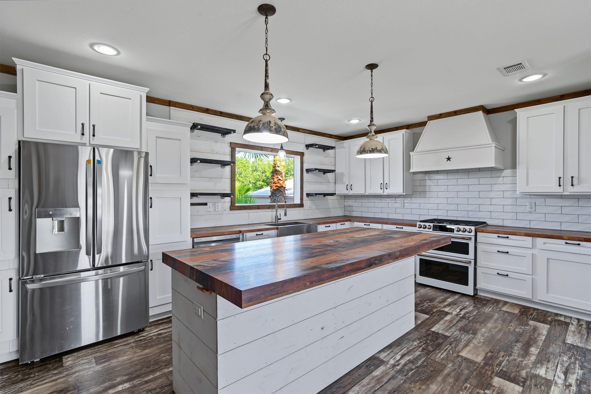 546 5th Street, Dickinson, TX 77539 Oversized Island Kitchen A spacious kitchen featuring a large center island, double oven, stainless-steel refrigerator, and matching stainless-steel appliances, offering plenty of room for cooking, gathering, and entertaining