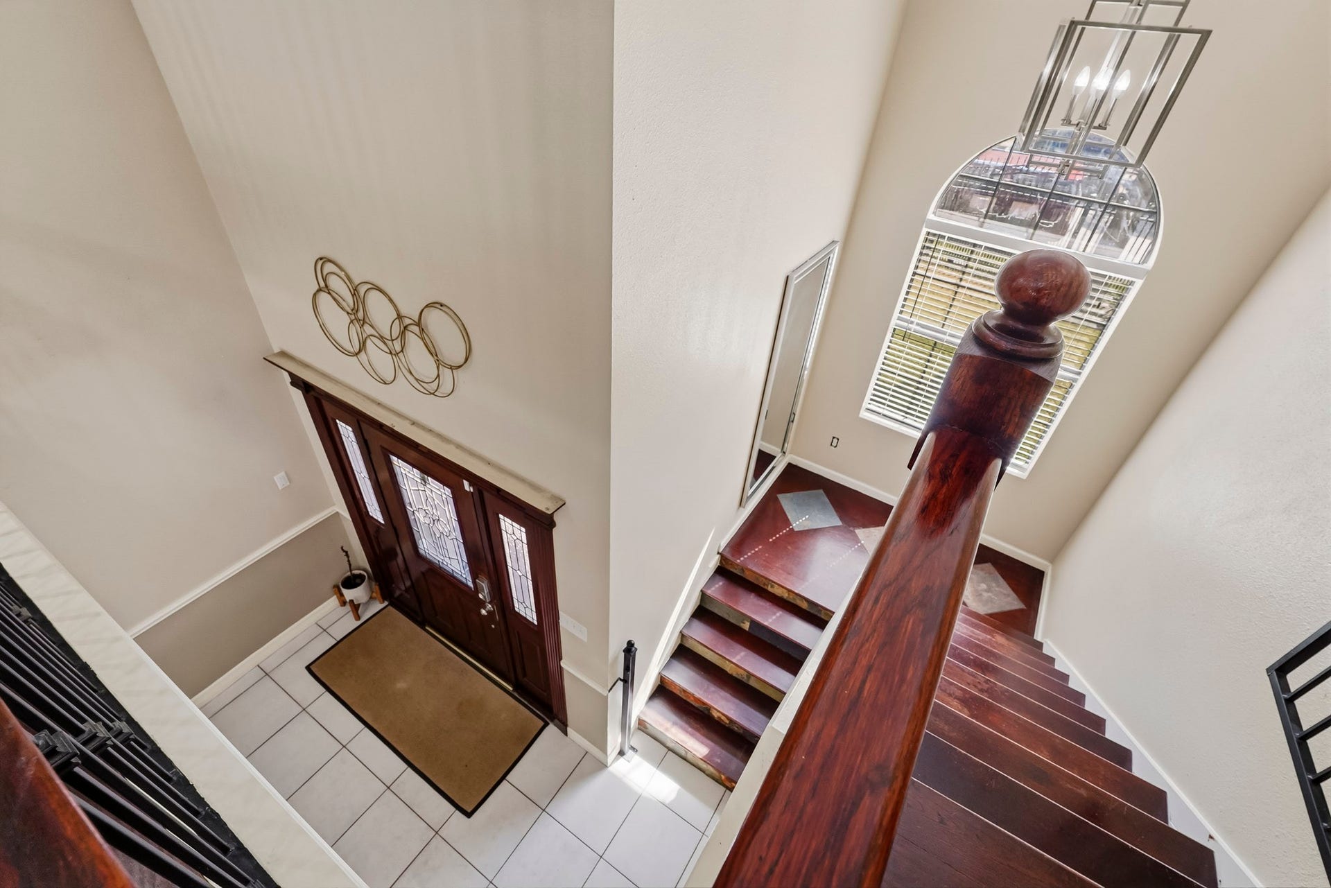 1207 9th Street, Galena Park, TX 77547 Elegant entryway with a grand staircase, featuring rich wood accents and abundant natural light from a large arched window.