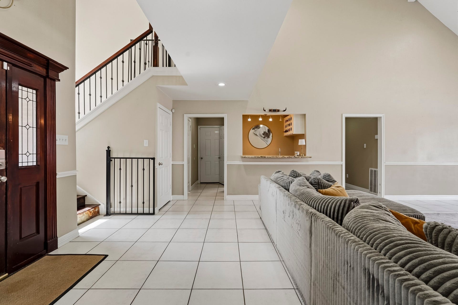 1207 9th Street, Galena Park, TX 77547 Spacious living area featuring high ceilings, elegant staircase, and a cozy lounge with plush seating, perfect for entertaining or relaxing.