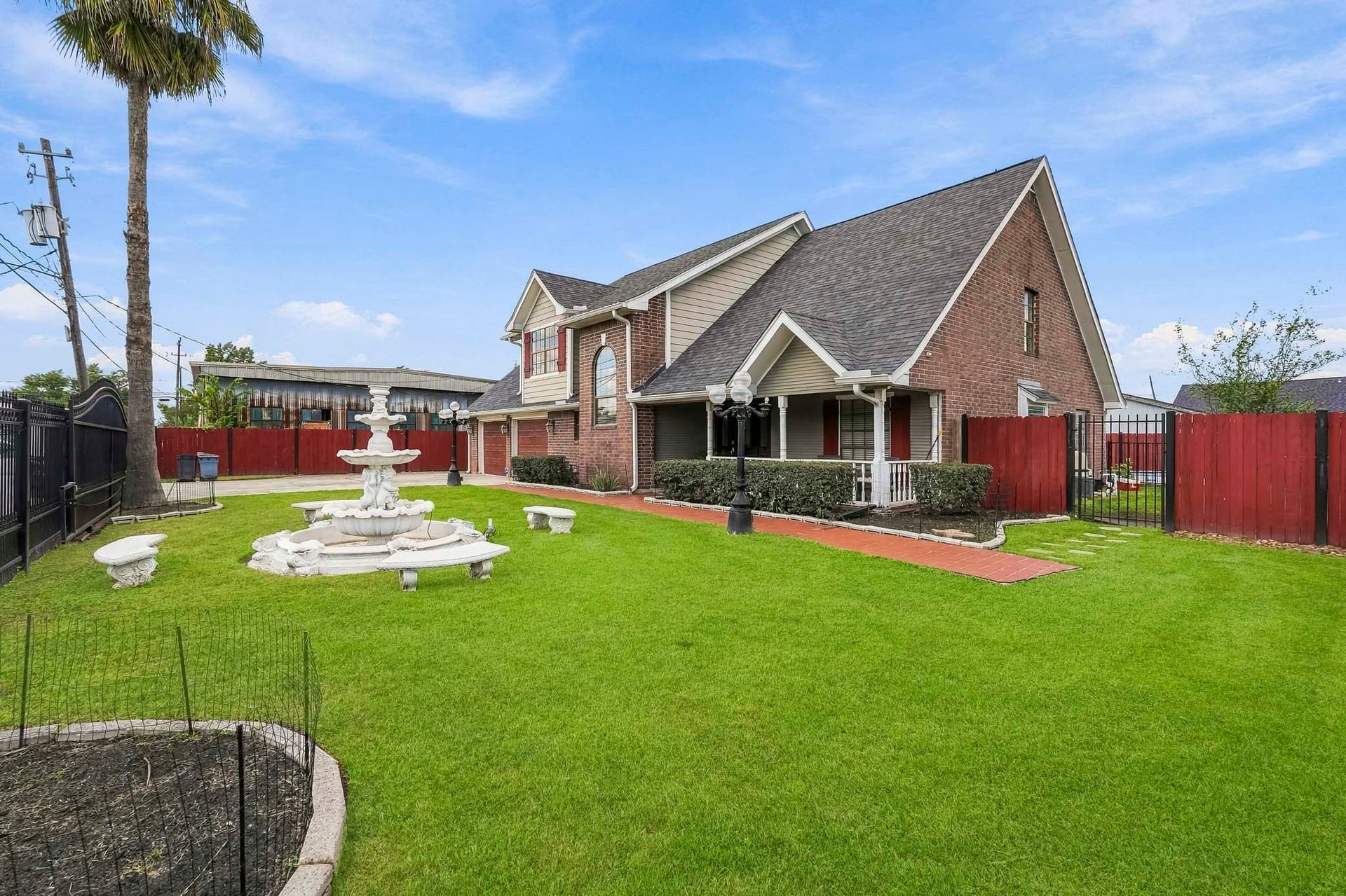 1207 9th Street, Galena Park, TX 77547 Charming brick home with a spacious yard, featuring a decorative fountain and a red brick pathway leading to the front entrance.