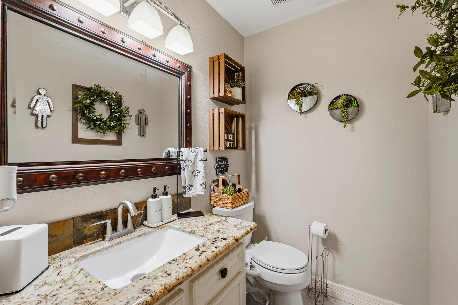 1207 9th Street, Galena Park, TX 77547 Charming half bathroom with a granite countertop, elegant mirror, and stylish decor.
