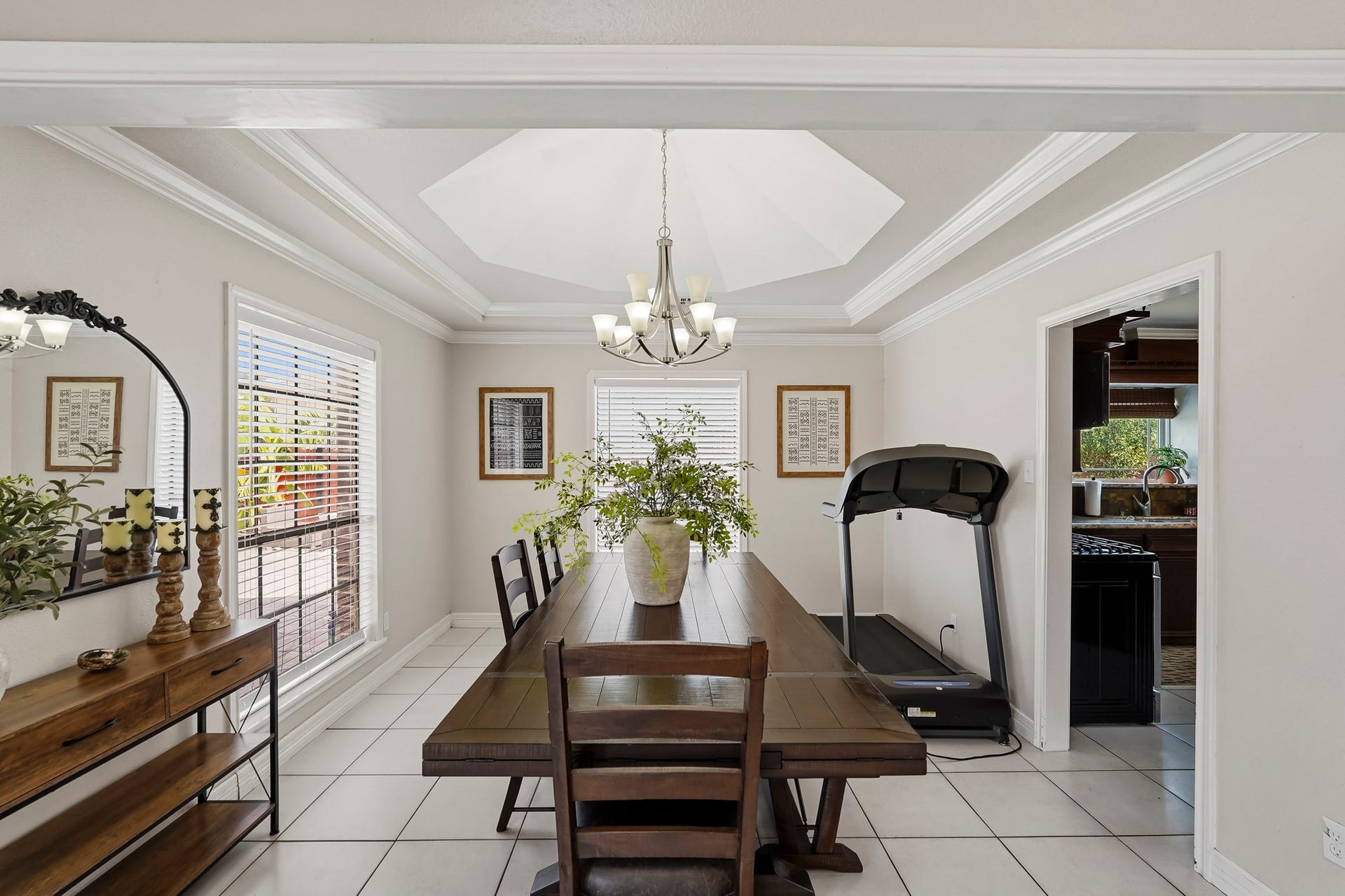 1207 9th Street, Galena Park, TX 77547 Elegant dining area with a coffered ceiling, stylish chandelier, and abundant natural light from large windows.