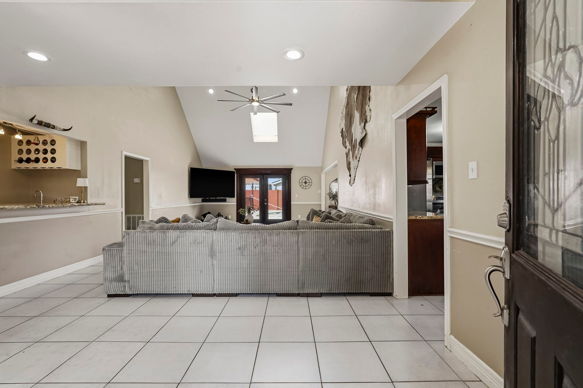 1207 9th Street, Galena Park, TX 77547 Spacious living area with high ceilings and abundant natural light from the skylight. The open layout connects to the wet bar area, perfect for entertaining.