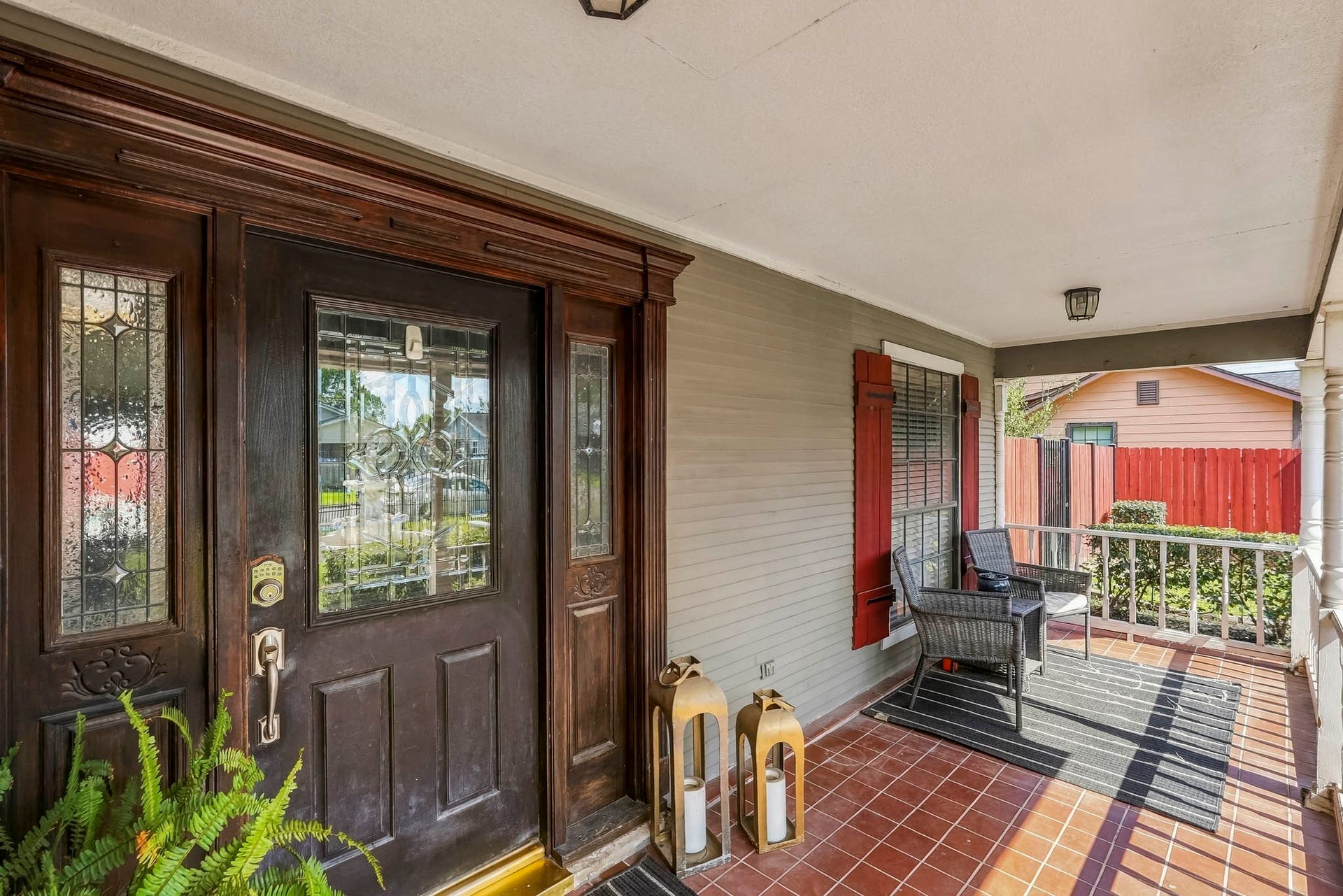 1207 9th Street, Galena Park, TX 77547 Charming front porch with elegant wood door, intricate glass panels, and cozy sitting area, perfect for welcoming guests.