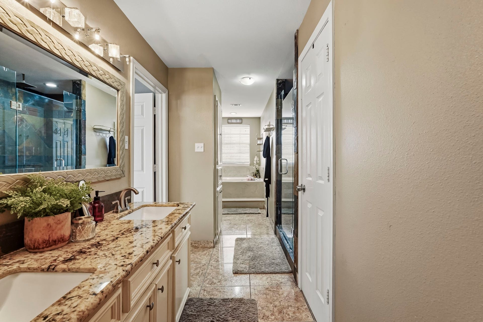 1207 9th Street, Galena Park, TX 77547 Primary bathroom features spacious double vanity with granite countertops, a large framed mirror, and a luxurious glass-enclosed shower.