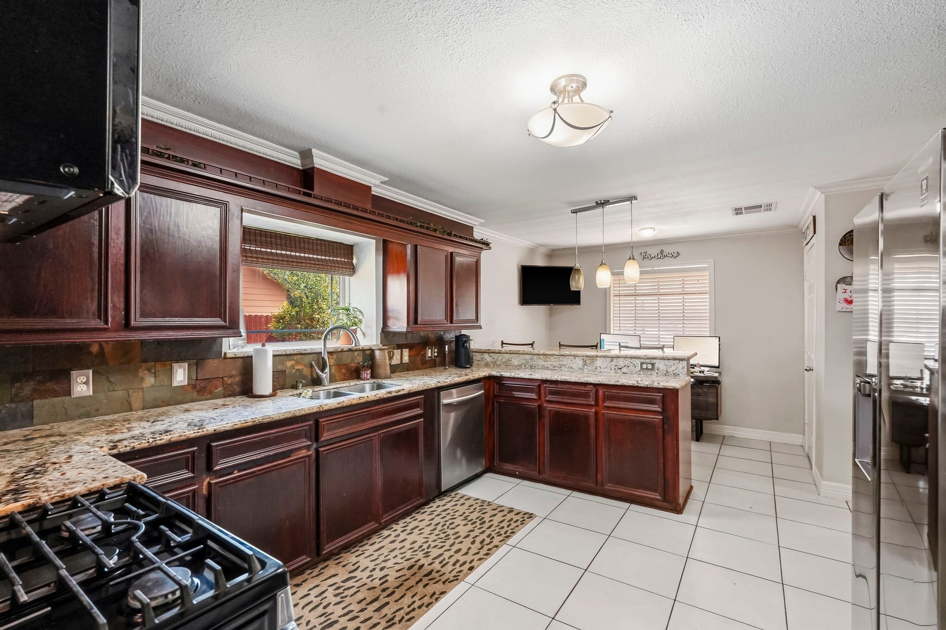 1207 9th Street, Galena Park, TX 77547 Spacious kitchen with rich wood cabinetry, granite countertops, and modern stainless steel appliances, offering a perfect blend of style and functionality.