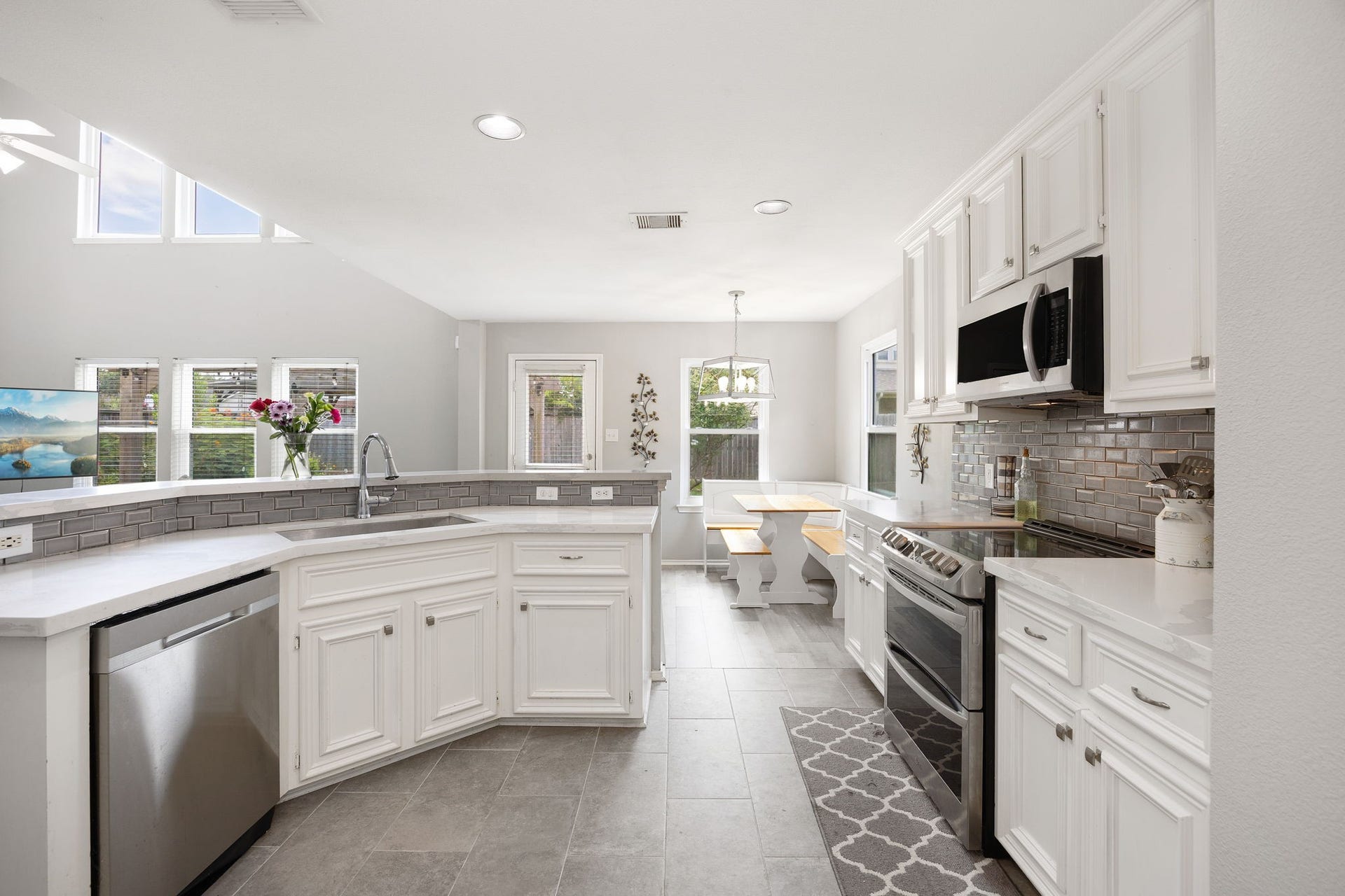 3915 Eastland Lake Drive, Richmond, TX 77406 Sweeping across the main workspace, the kitchen features a stainless steel dishwasher, an electric cooktop, and refined marble countertops.
