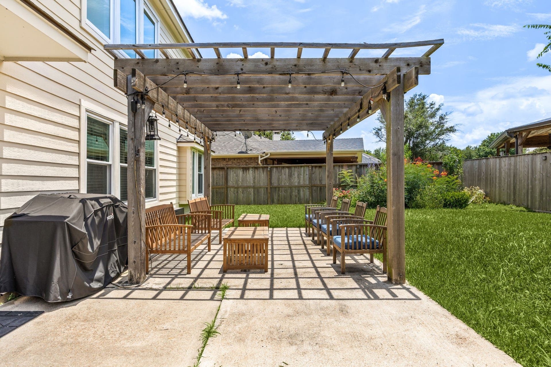 3915 Eastland Lake Drive, Richmond, TX 77406 The custom wood pergola installed on the open concrete patio in 2021 provides a shaded outdoor living space perfect for comfortable seating arrangement and relaxation.