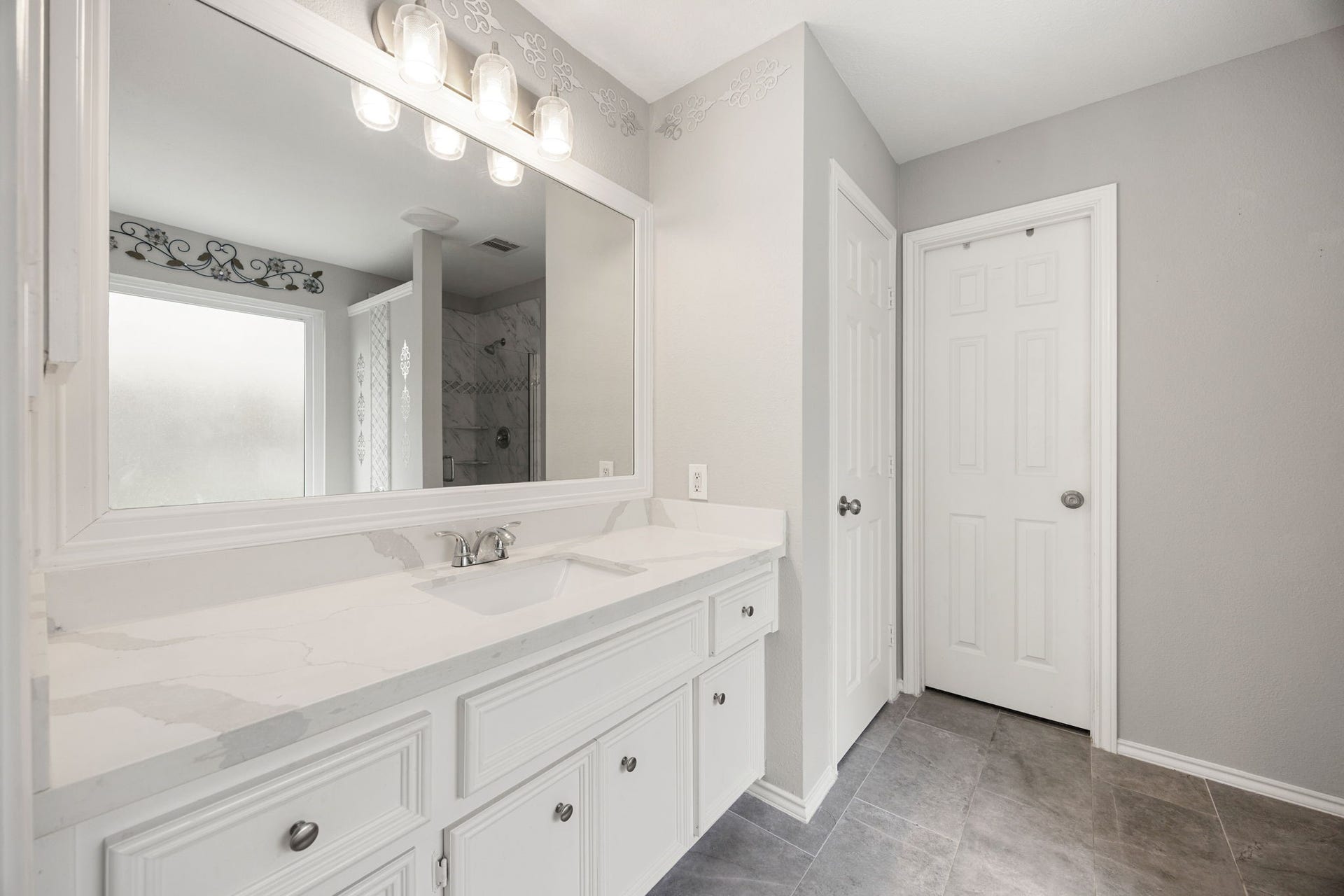 3915 Eastland Lake Drive, Richmond, TX 77406 The primary en-suite bathroom highlights an extended white vanity with under-counter storage drawers, and a sophisticated quartz-look counters.