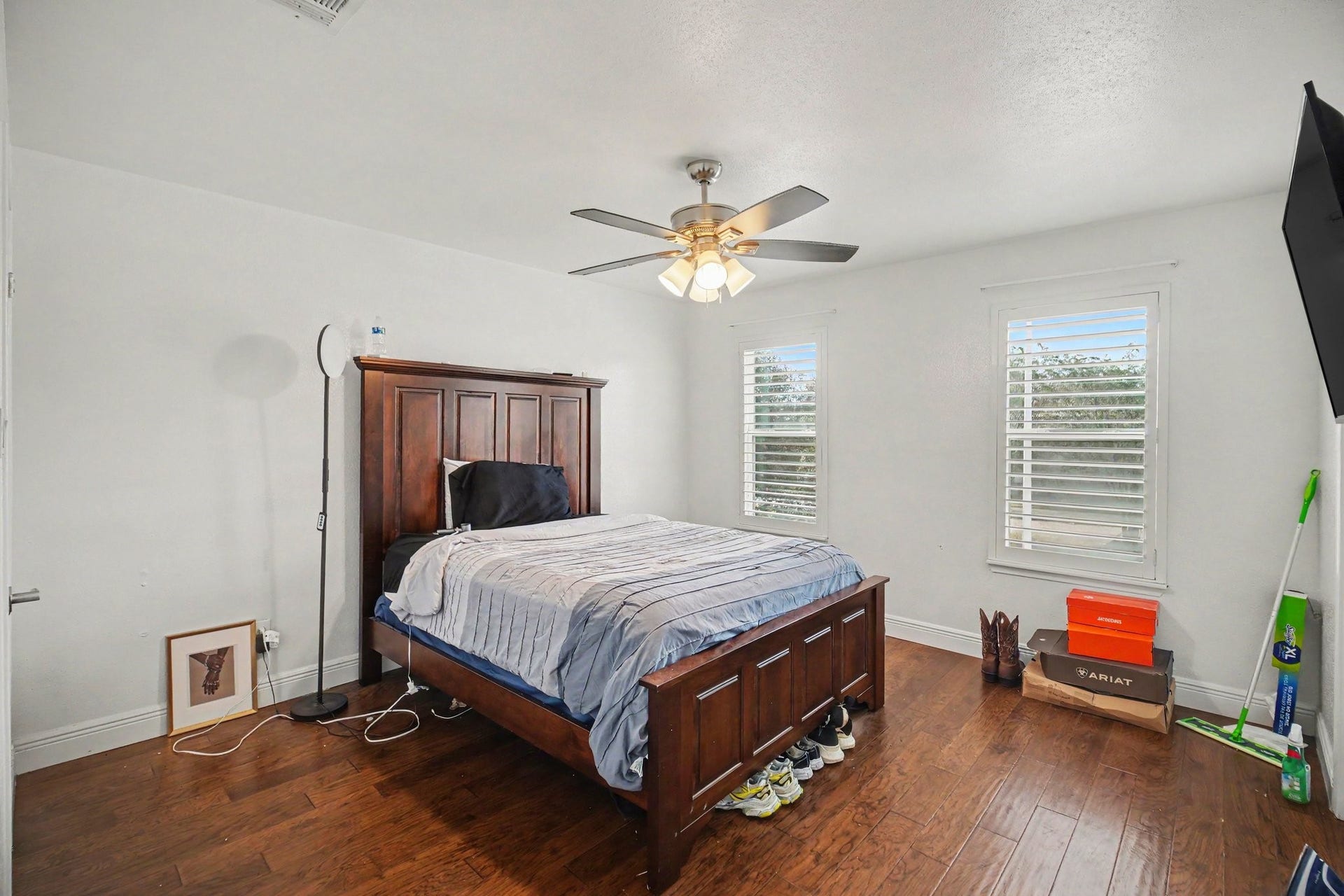 Spacious and inviting, the second bedroom boasts rich wood flooring, abundant natural light through dual windows, and a sleek ceiling fan for ultimate comfort.