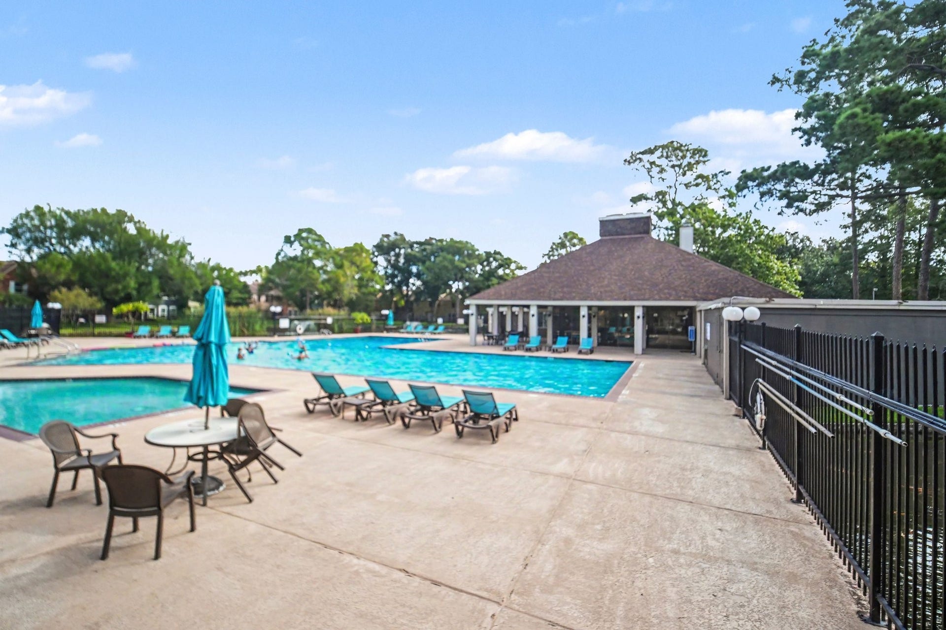 Dive into luxury with an Olympic-size pool perfect for both relaxation and serious swimming, surrounded by ample lounging space and lush greenery.