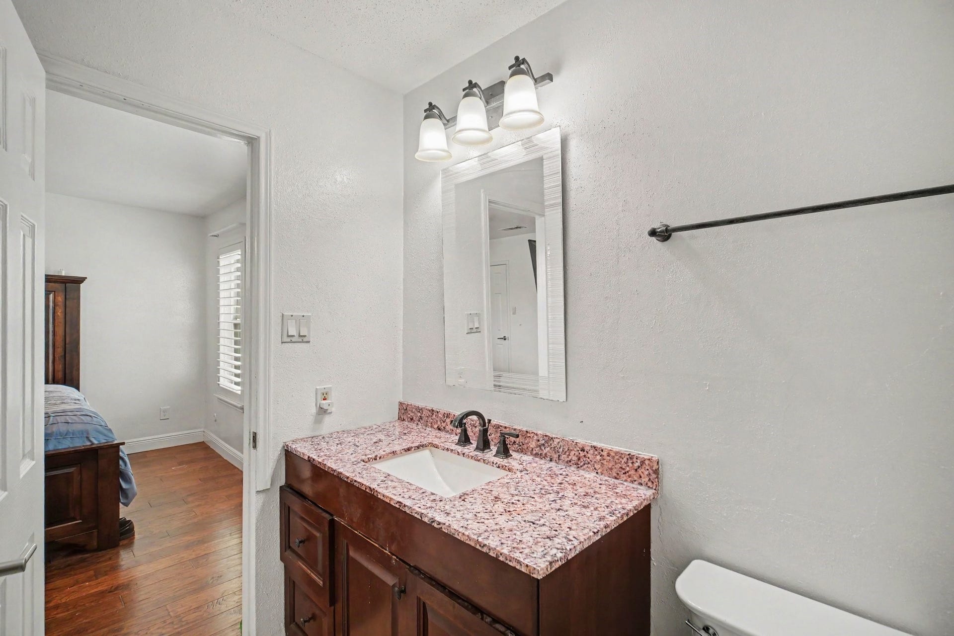 Experience modern elegance in this updated bath, featuring a chic vanity with a granite countertop and contemporary fixtures.