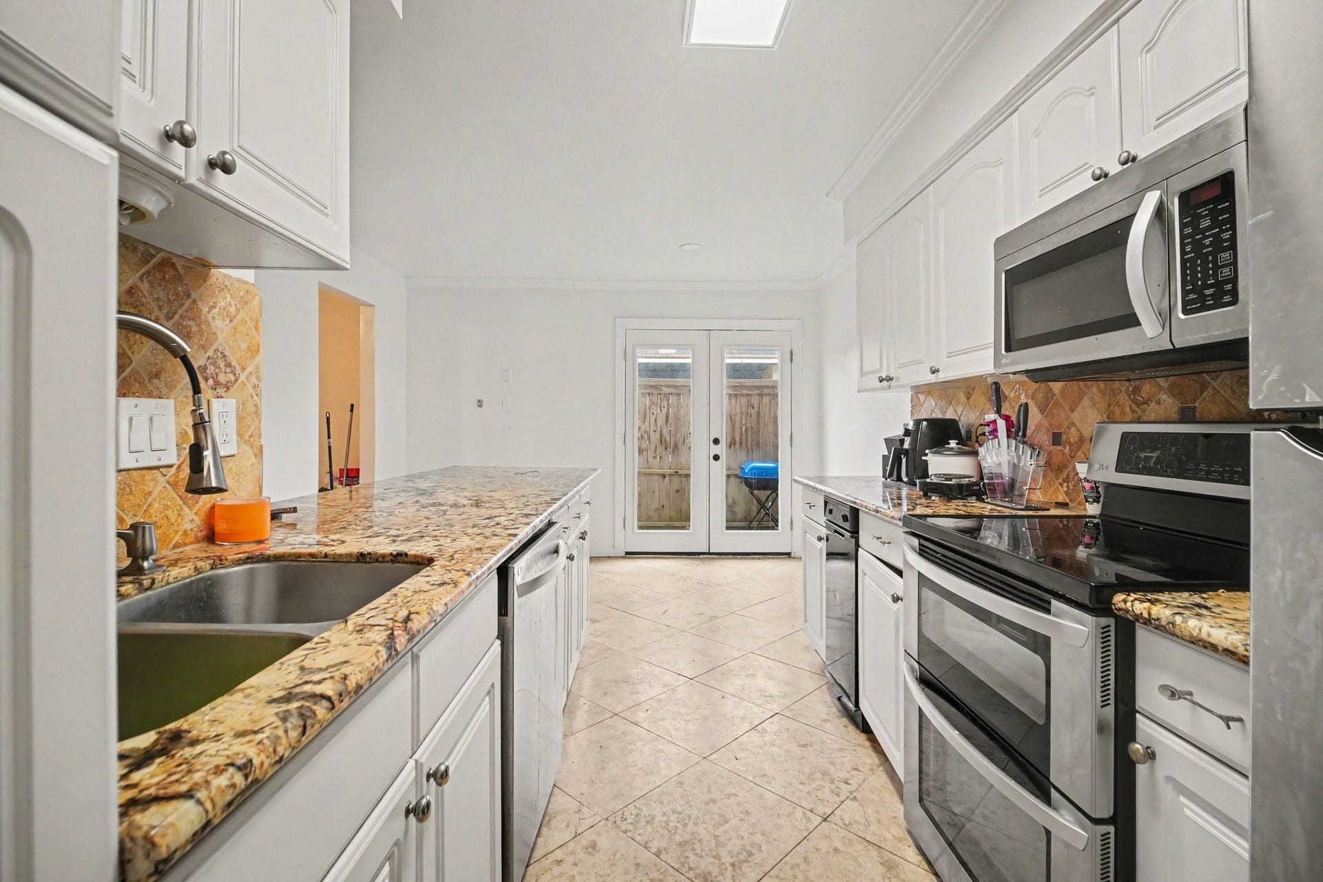 Experience culinary delight in this bright, modern kitchen featuring stunning granite countertops, sleek stainless steel appliances, and ample cabinetry for all your storage needs.