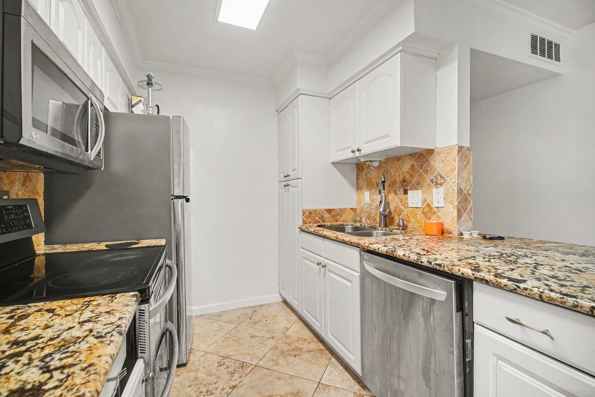 Experience culinary delight in this stylish kitchen featuring sleek stainless steel appliances, elegant granite countertops, and charming tile accents.