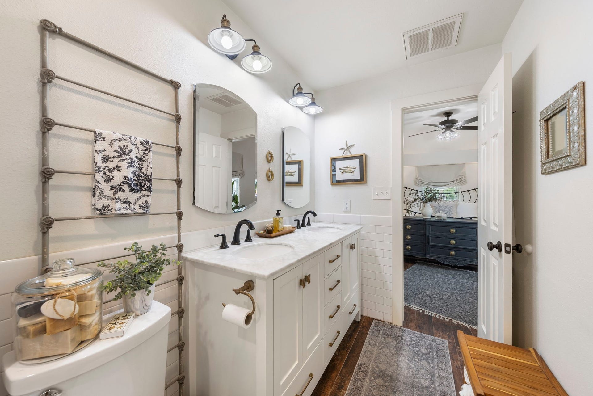 The renovated primary bath features a dual-sink quartz vanity with abundant storage, stylish fixtures, and direct access to the spacious primary suite, creating a seamless and private retreat.