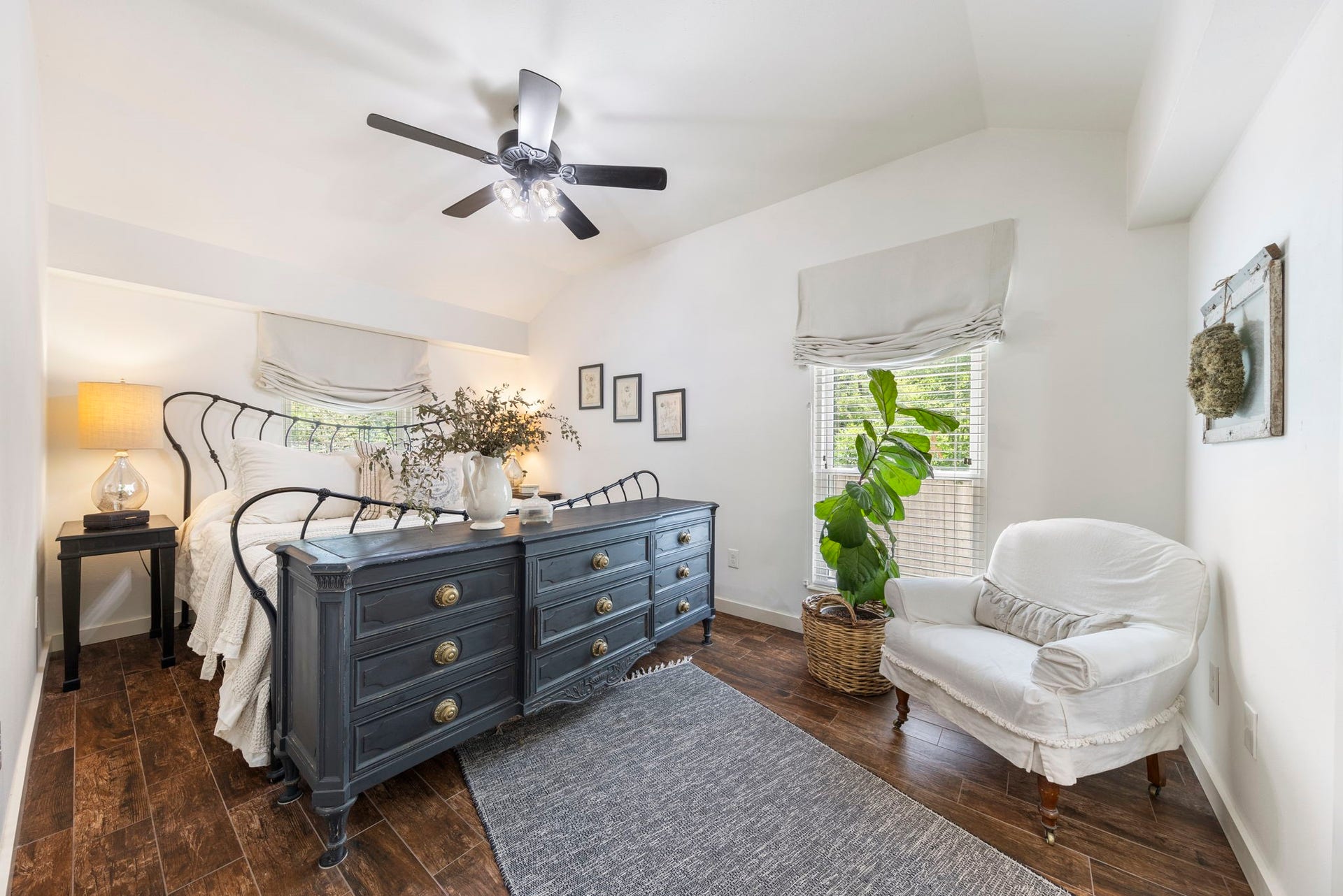 The spacious primary suite offers vaulted ceilings, rich wood-look flooring, abundant natural light, and plenty of room for a sitting area, creating a comfortable and relaxing retreat.