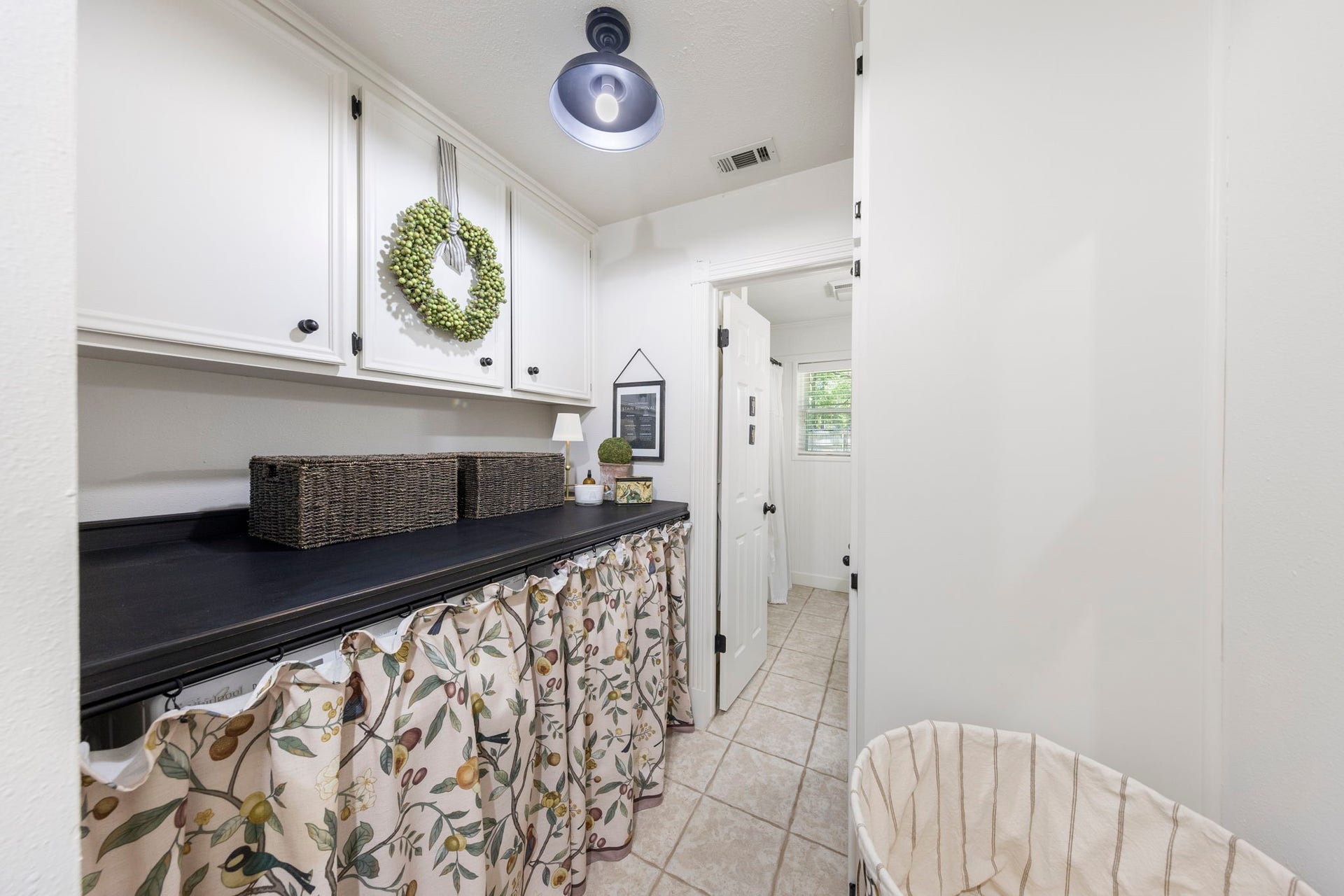 Functional laundry room with built-in upper cabinetry, a folding counter, and additional storage to keep everyday essentials organized and out of sight.