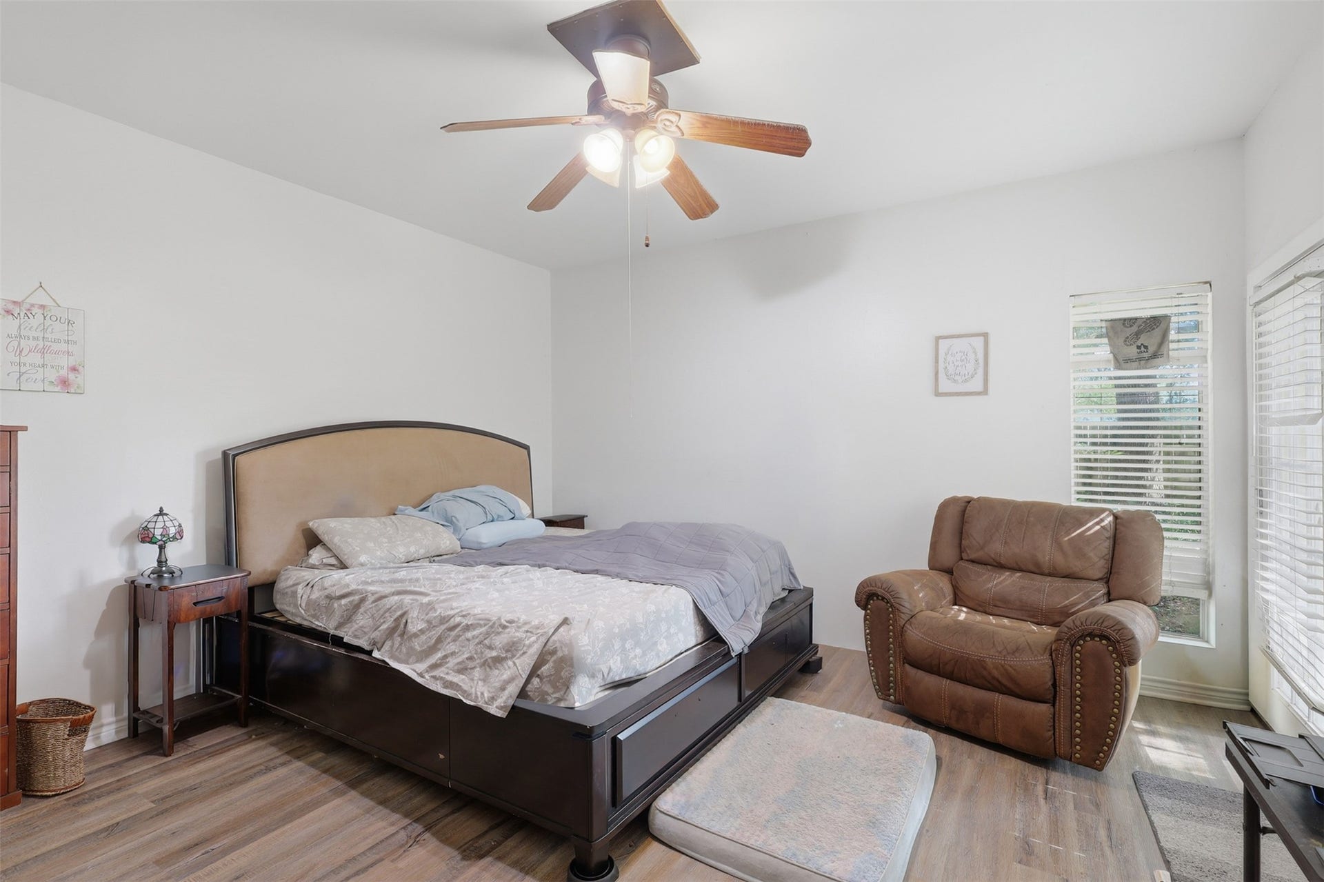 Generous bedroom footprint easily accommodates king-sized furniture with warm wood-look floors and private yard access.