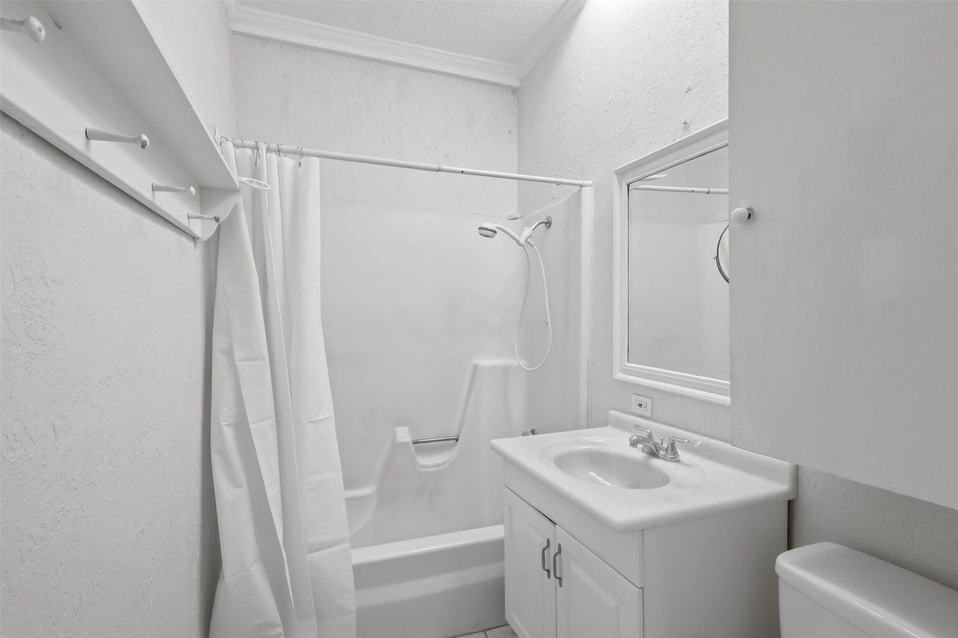 Efficient full bathroom layout equipped with a crisp white vanity, integrated shower-tub, and overhead skylight for natural daytime illumination.