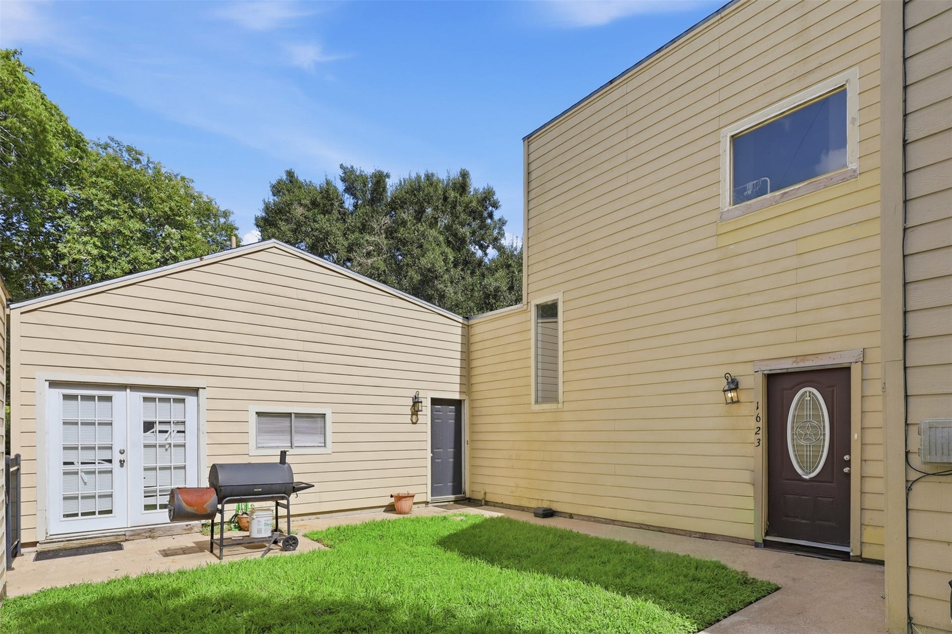 Lush grassy courtyard connects multiple ground-floor entry points, creating a cozy and secure outdoor gathering space.