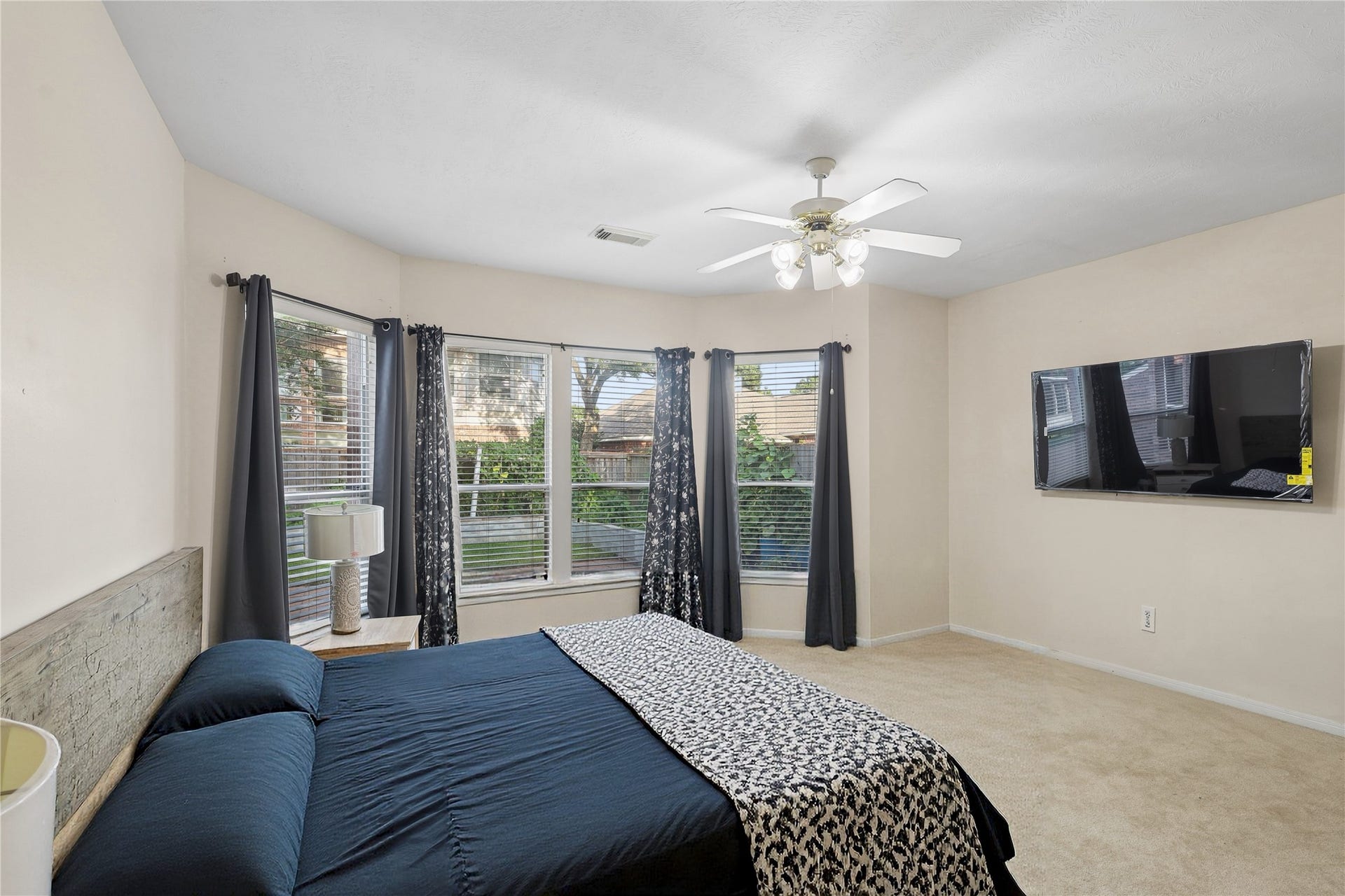 2614 Sunset Lake Drive, Sugar Land, TX 77478 This spacious bedroom features large bay windows with abundant natural light, neutral walls, and carpet flooring.