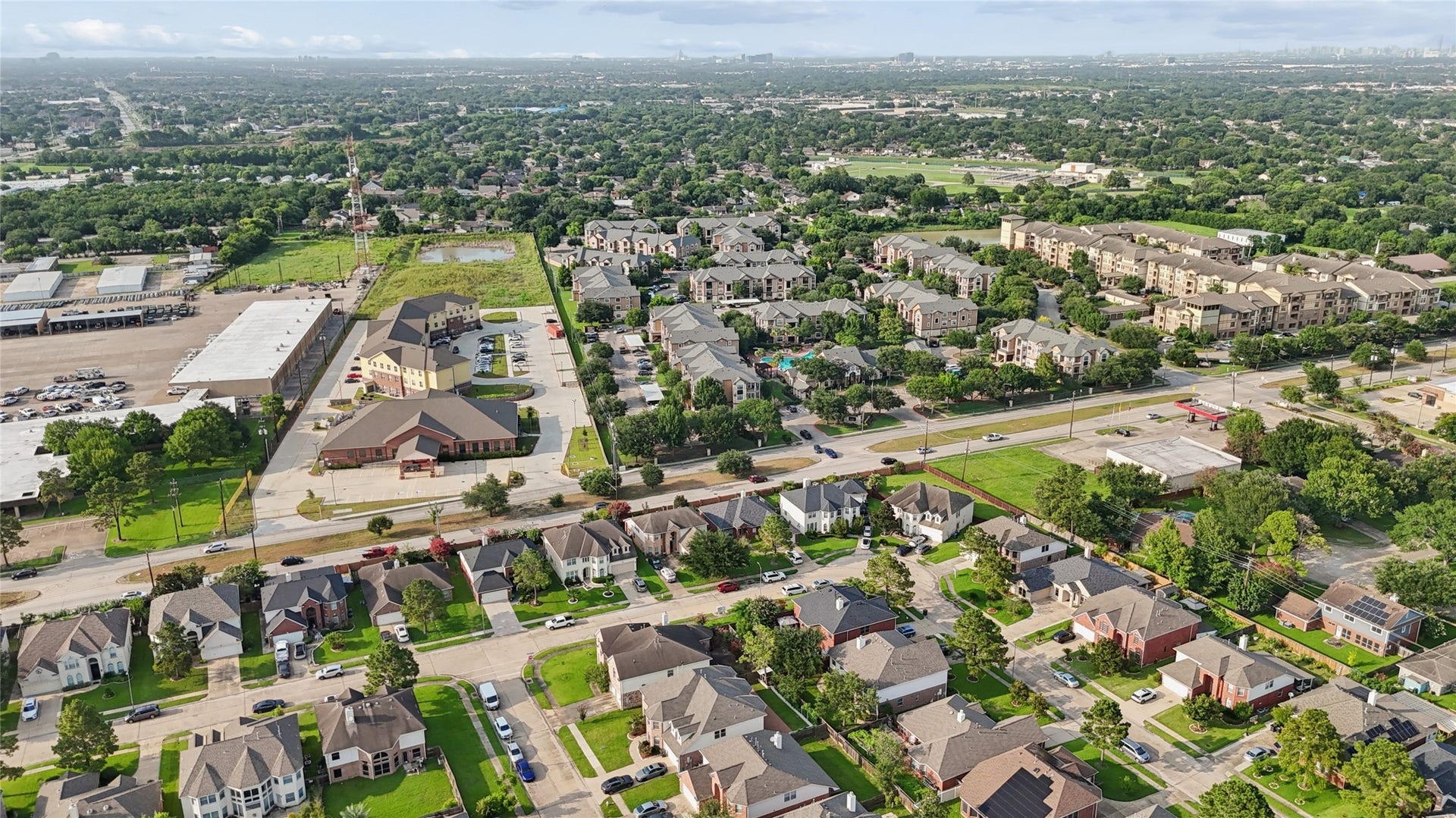 2614 Sunset Lake Drive, Sugar Land, TX 77478 This aerial photo showcases a suburban neighborhood with well-maintained single-family homes, tree-lined streets, and nearby commercial buildings. The area appears spacious and green, offering a mix of residential and commercial conveniences.