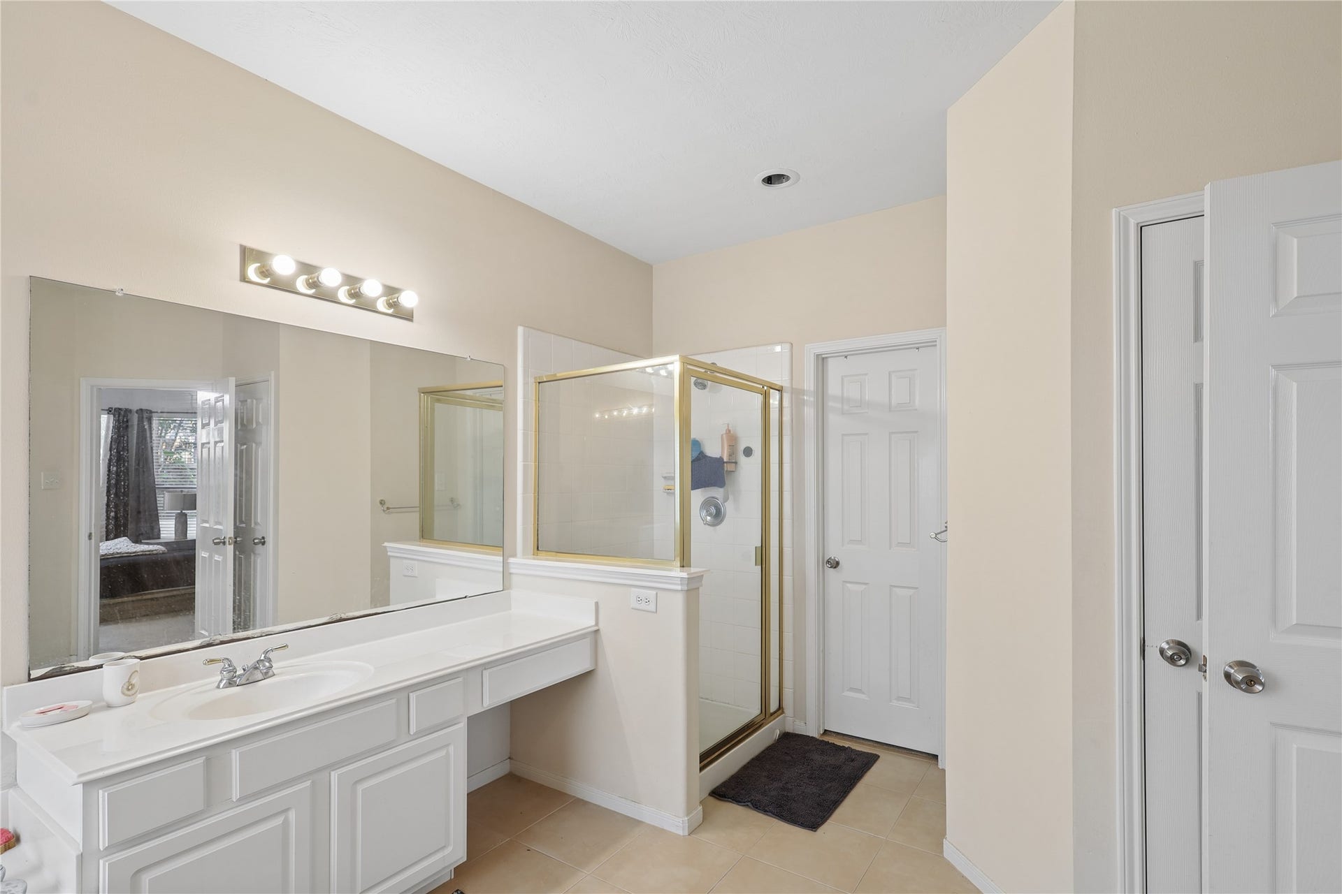 2614 Sunset Lake Drive, Sugar Land, TX 77478 Bright, spacious bathroom with a large mirror, ample counter space, and a glass-enclosed shower. Neutral tones create a clean, modern look.