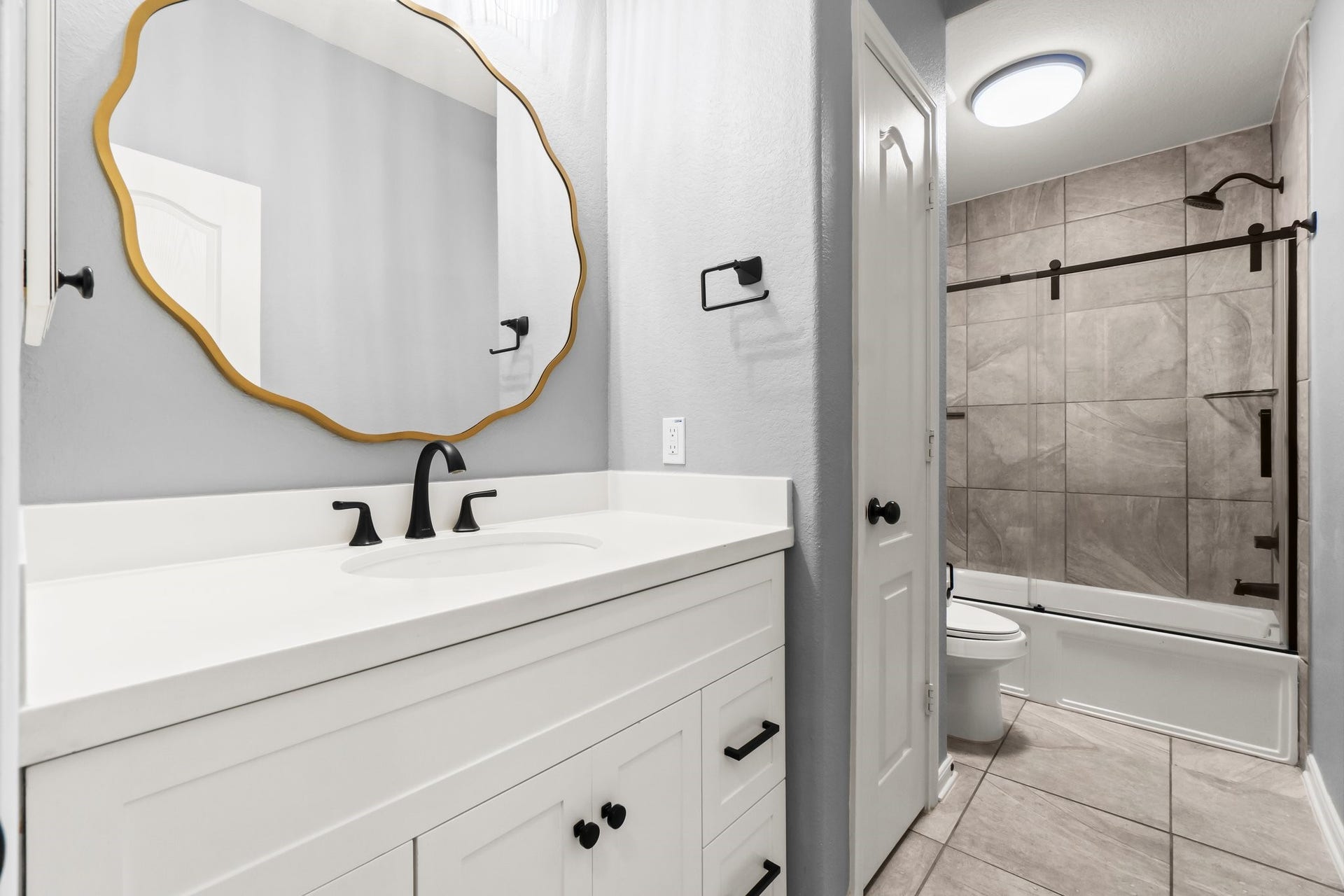The fully upgraded upstairs bathroom features a sleek glass-enclosed shower and premium finishes.
