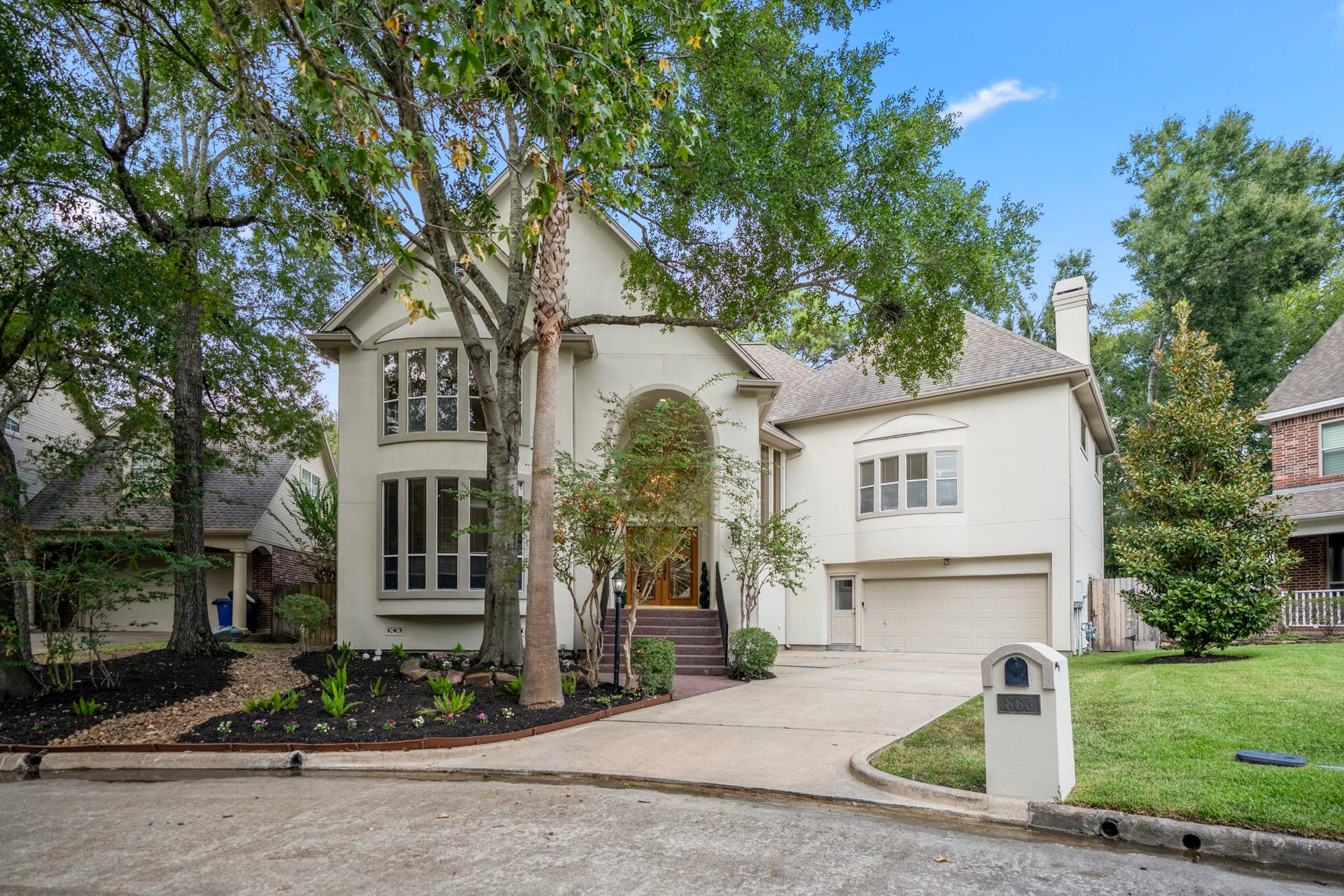 863 Plainwood Drive, Houston, TX 77079 A long driveway leads to the attached two-car garage and elevated front entrance.