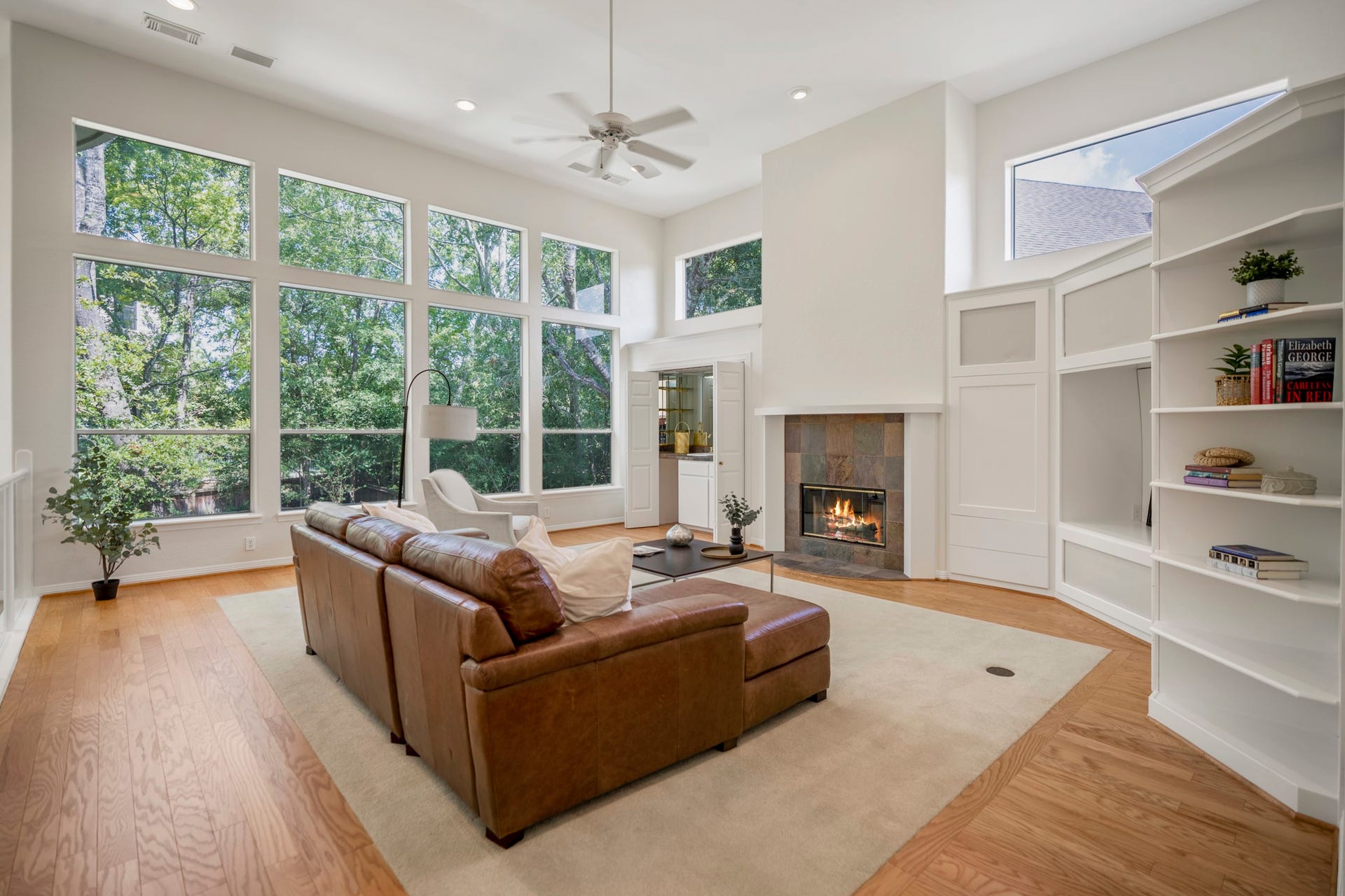863 Plainwood Drive, Houston, TX 77079 Walls of windows frame views of the mature trees and backyard.