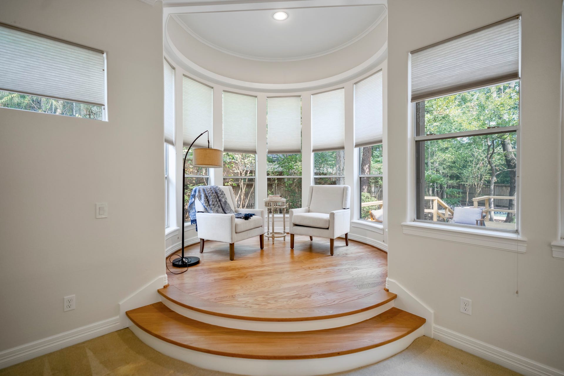 863 Plainwood Drive, Houston, TX 77079 A separate sitting area is framed by curved windows and peaceful views of the mature trees.