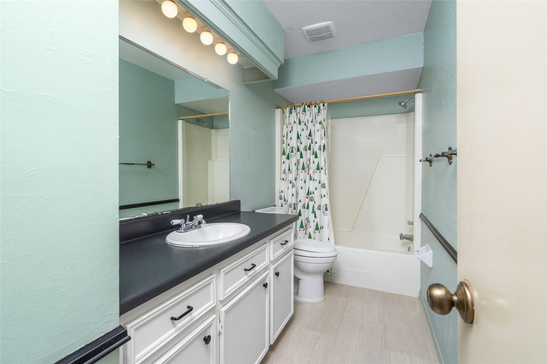 7015 Rosebrook Circle, Spring, TX 77379 Full guest bathroom is equipped with long vanity counter space, custom trim, and a clean tub-shower combo.