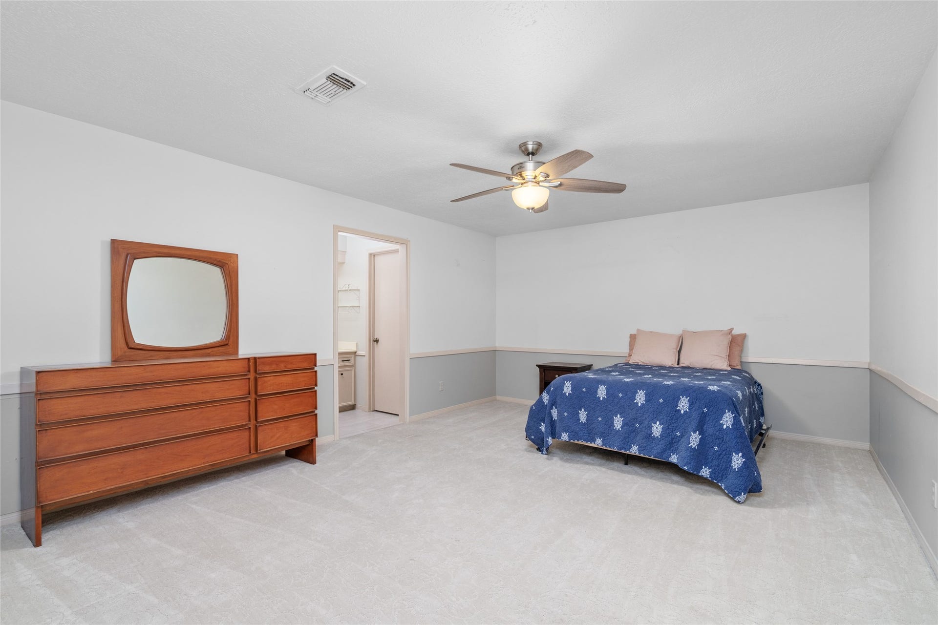 7015 Rosebrook Circle, Spring, TX 77379 Peaceful primary bedroom retreat offers crisp neutral walls, plush carpeting, and en-suite bath access.