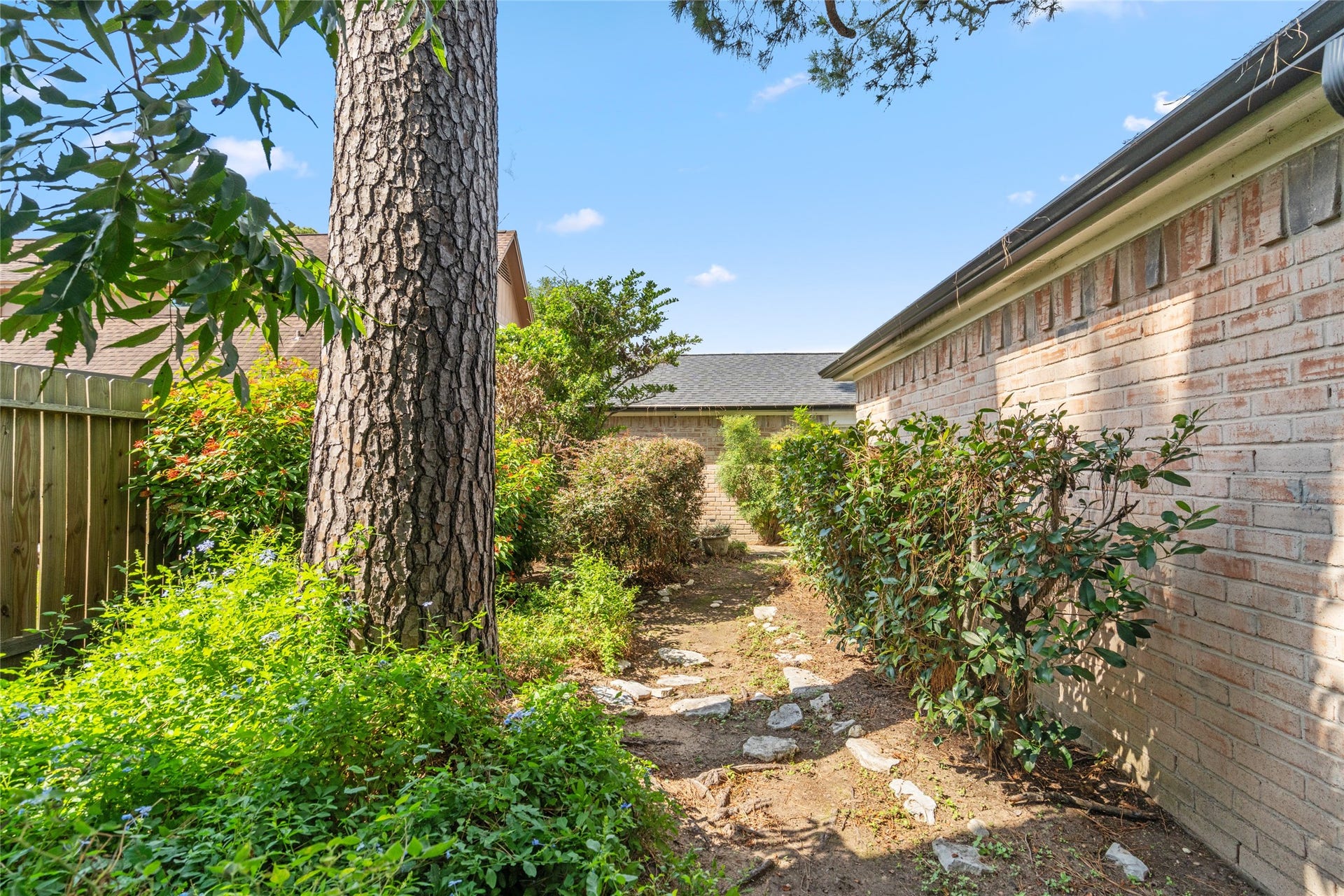 7015 Rosebrook Circle, Spring, TX 77379 Charming garden path surrounded by lush greenery, mature shade trees, and privacy fencing.