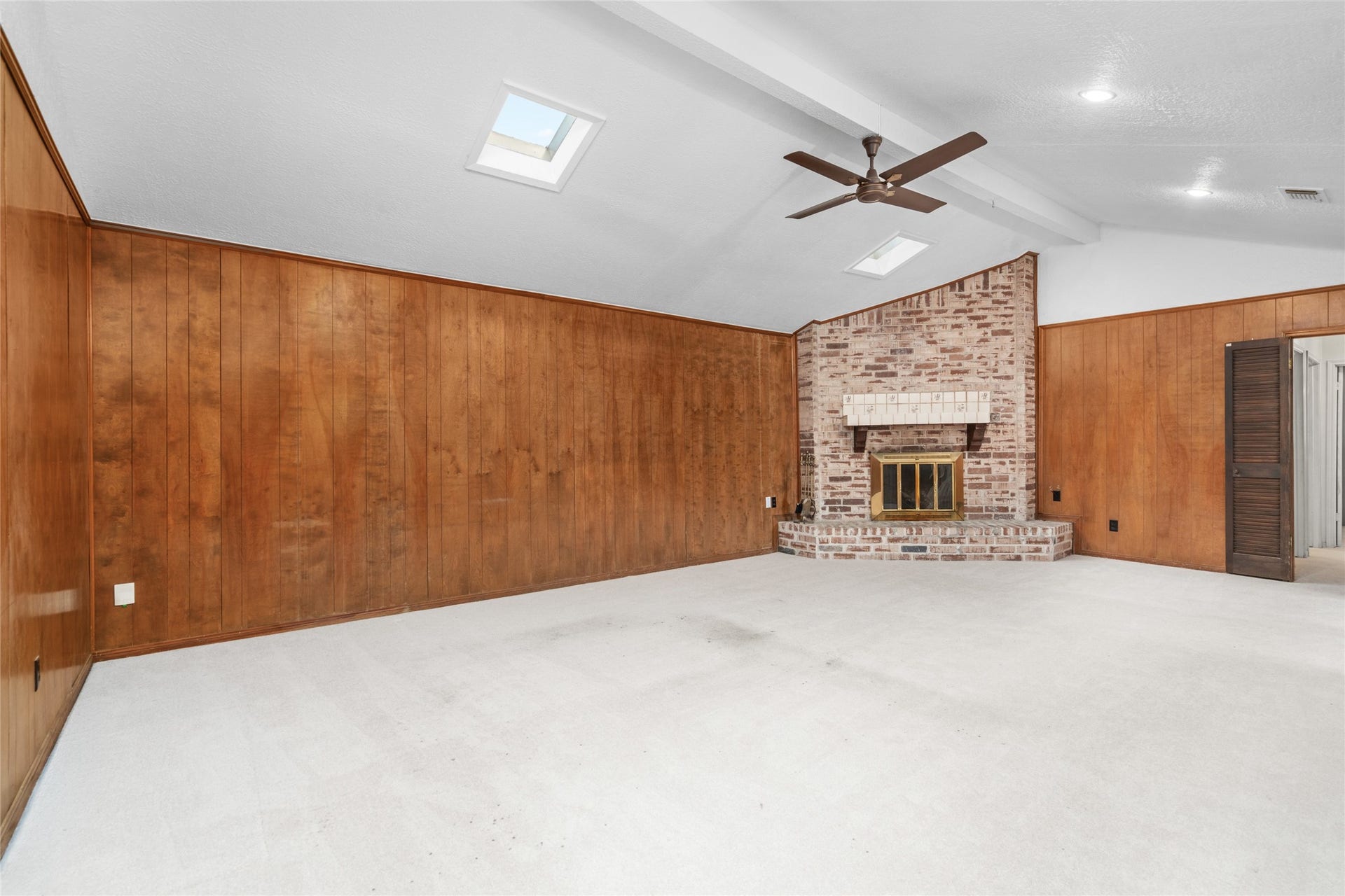 7015 Rosebrook Circle, Spring, TX 77379 Expansive family room perspective shows off high ceilings, natural light, and classic wood paneling.