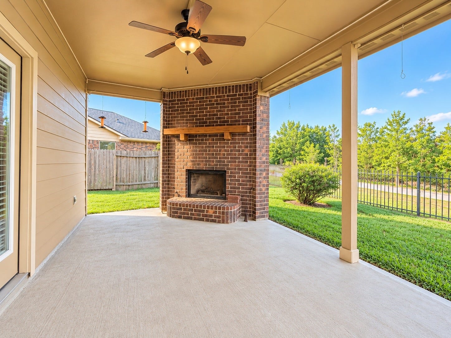 Enjoy the covered outdoor living space with a cozy fireplace, no rear neighbors, and views of the neighborhood walking trail!