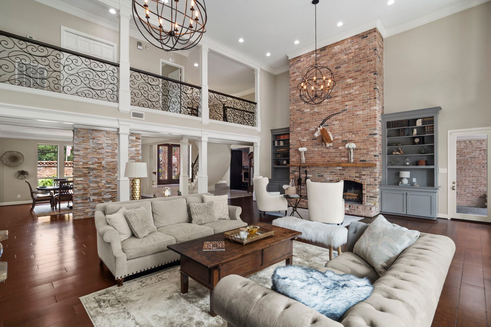 An upstairs gallery overlooks the great room, highlighted by intricate custom ironwork.