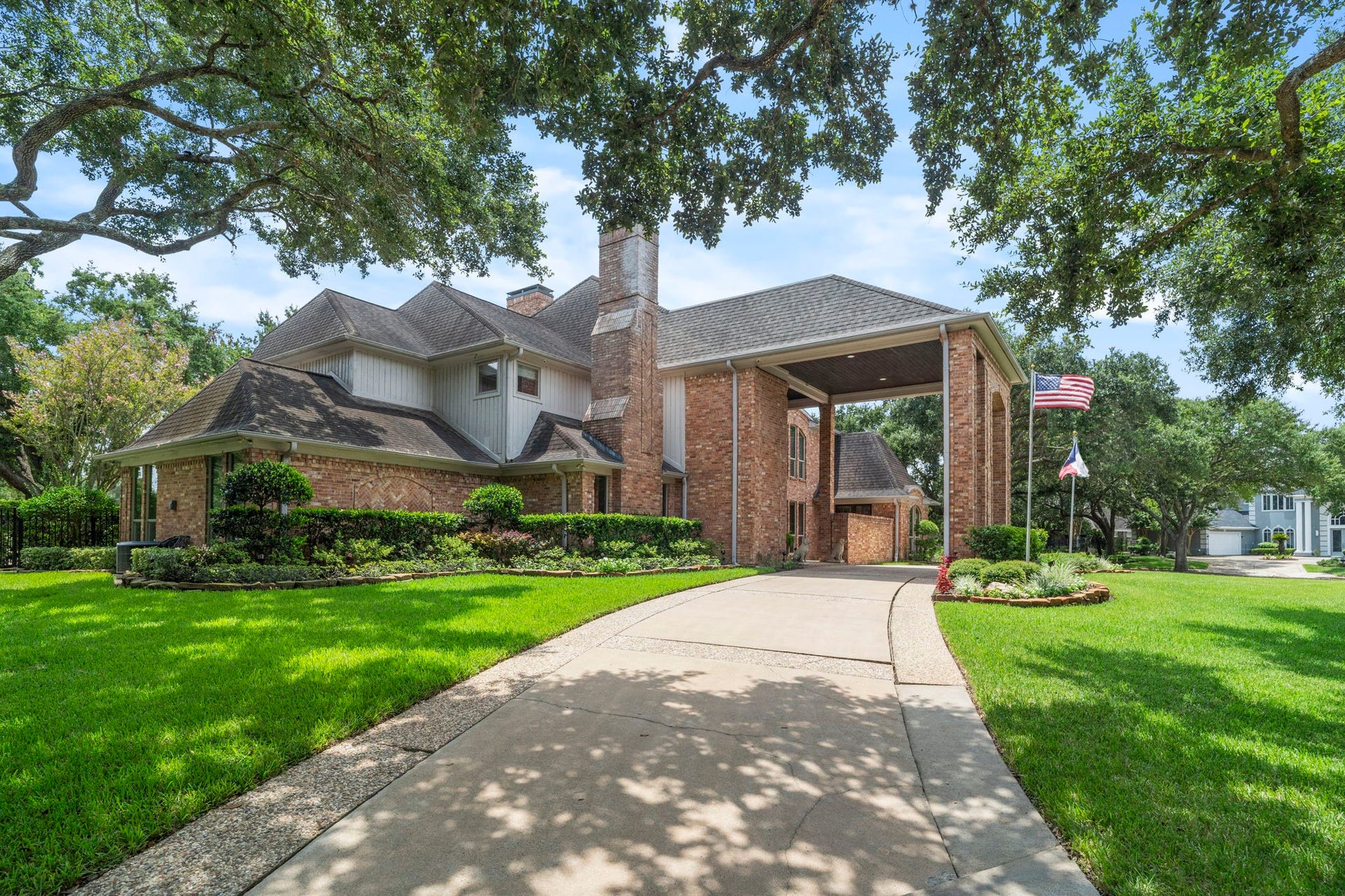 A circular front driveway leads to a dramatic two-story porte cochre, creating a grand arrival experience.