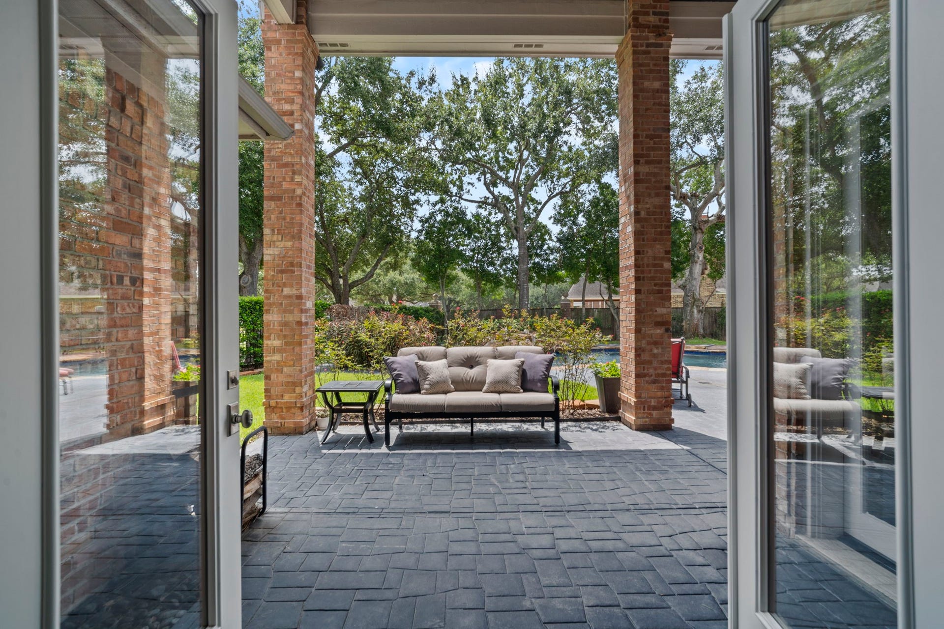 French doors open to the covered back patio and pool, offering a tranquil outdoor living space.