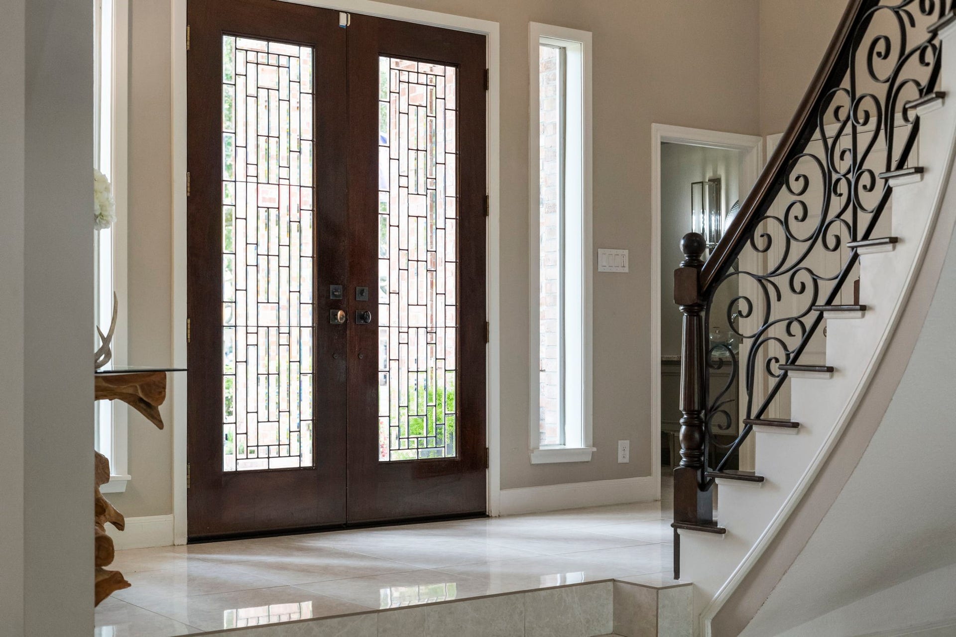 Contemporary wood and leaded glass double doors fill the foyer with soft natural light while preserving privacy.