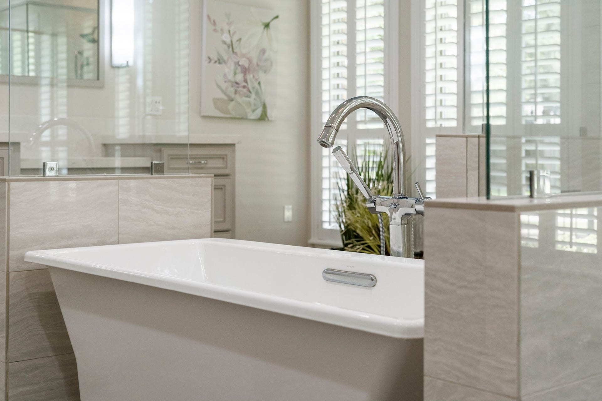 A sculptural freestanding soaking tub and elegant arched faucet create a luxurious focal point in the owner's bath.