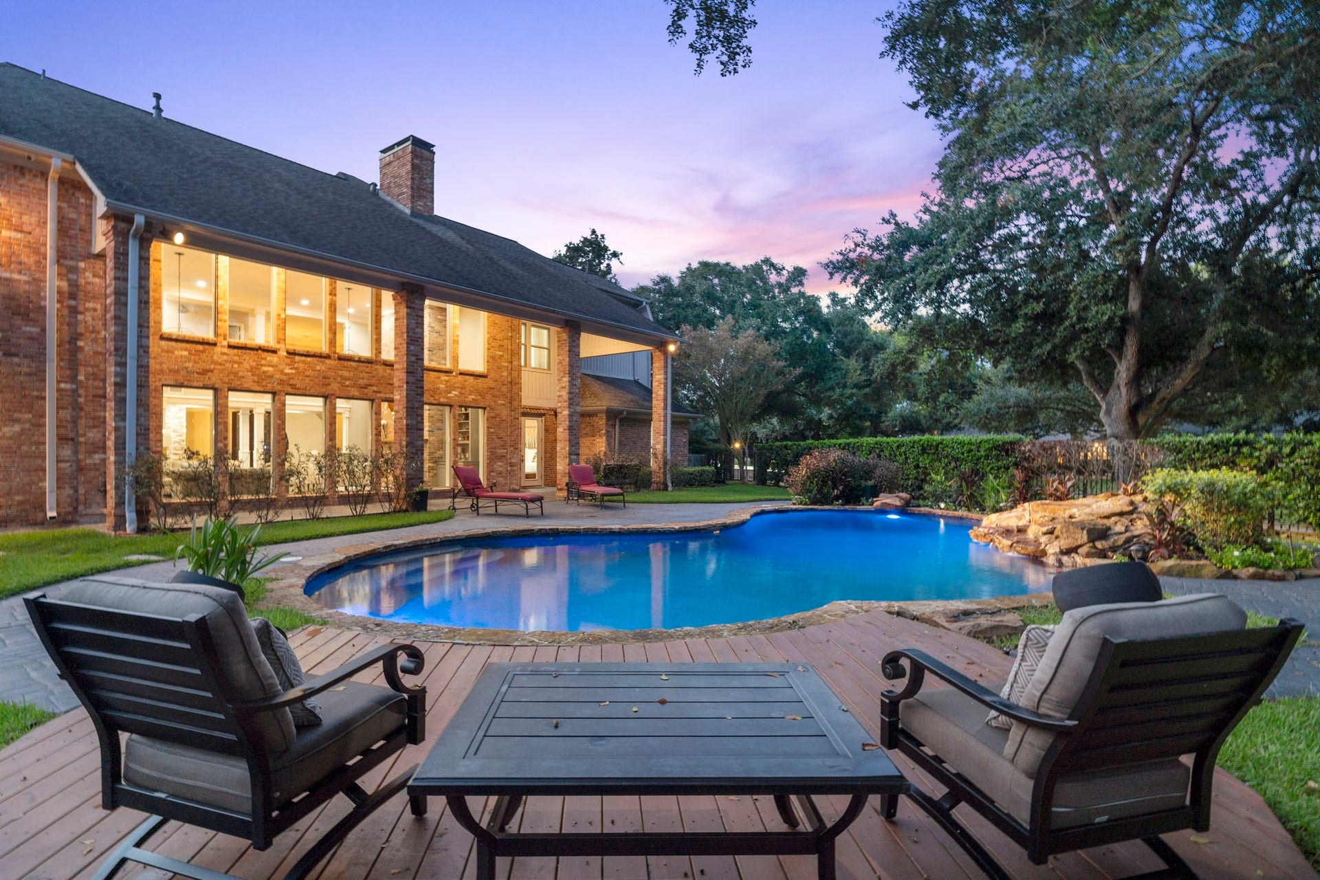 Surrounding the pool, multiple seating areas and a decked patio provide versatile spaces for lounging and outdoor gatherings.