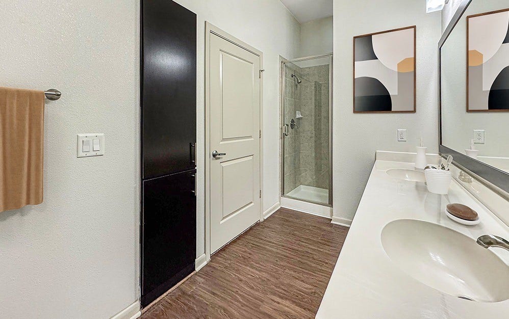Bathroom featuring a double-sink vanity and additional cabinetry, offering enhanced storage and everyday convenience.
