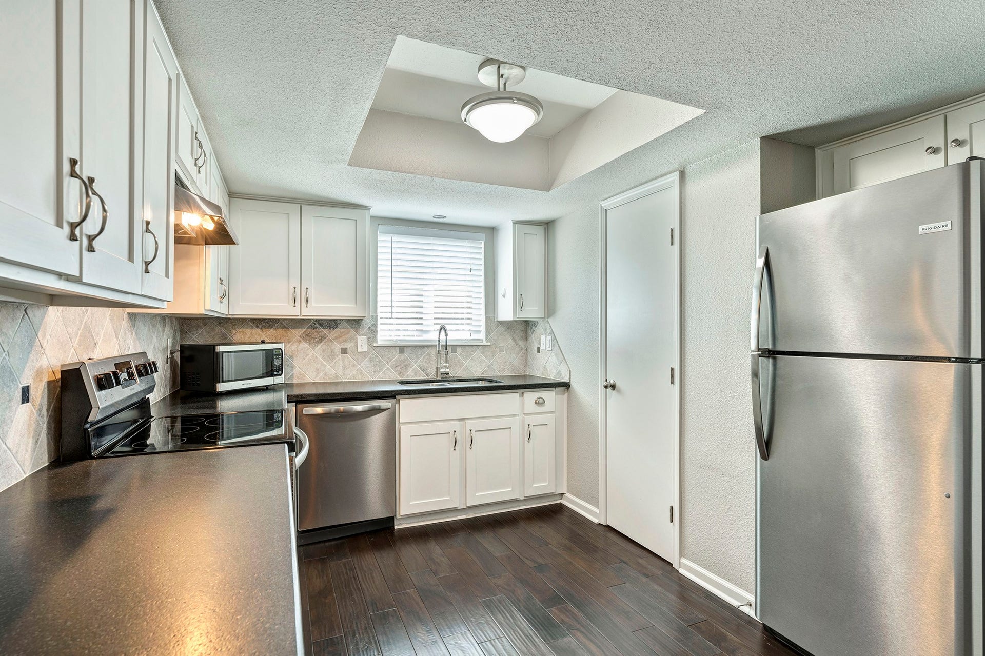 5005 Georgi Lane, #165, Houston, TX 77092 Granite kitchen offers stainless steel appliances including refrigerator and microwave plus pantry.