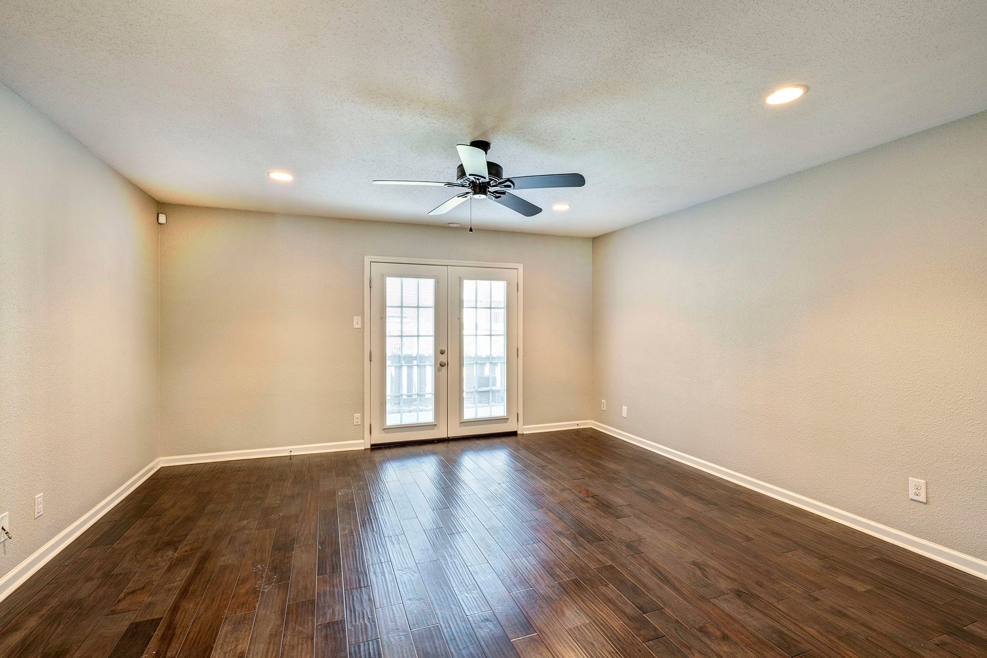 5005 Georgi Lane, #165, Houston, TX 77092 Spacious living room with engineered wood flooring, ceiling fan and recessed lighting. French doors open to the back patio.