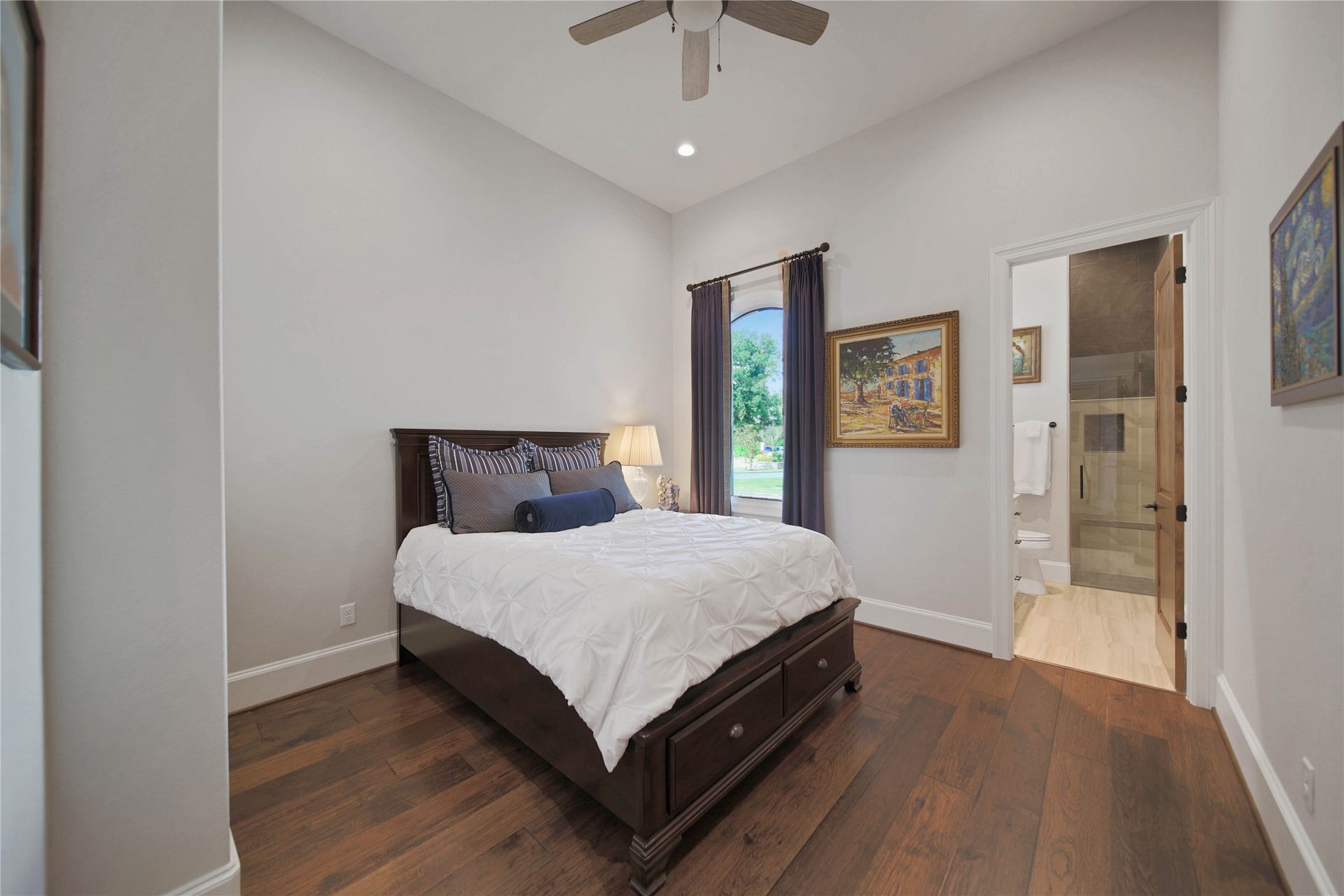 24718 Shadow Pond Drive, Spring, TX 77389 Cozy bedroom with hardwood floors, a large window for natural light, and an en-suite bathroom for added convenience.