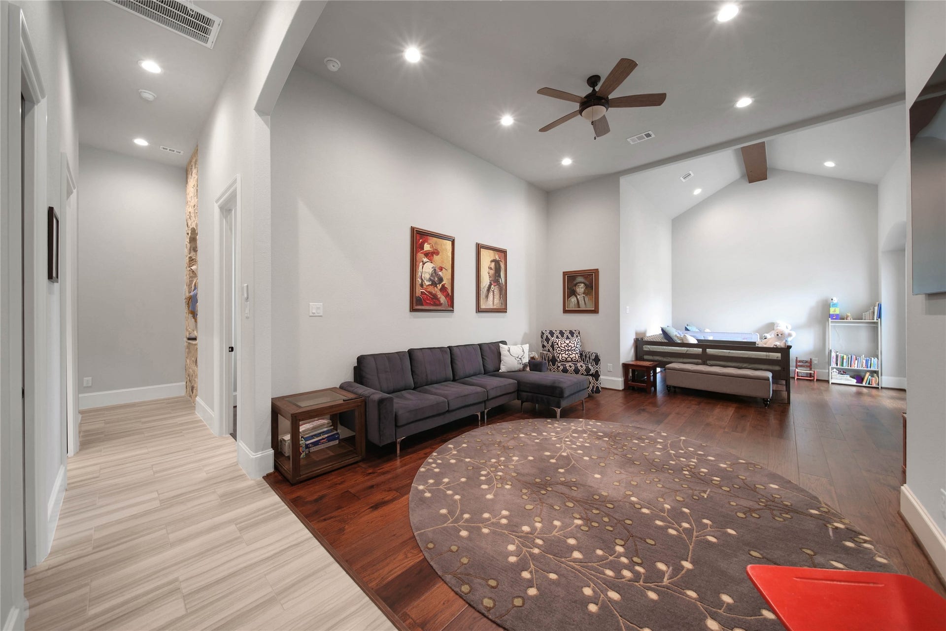 24718 Shadow Pond Drive, Spring, TX 77389 Spacious living area with rich hardwood floors, recessed lighting, and a cozy seating arrangement, leading to a versatile bonus space perfect for relaxation or play.